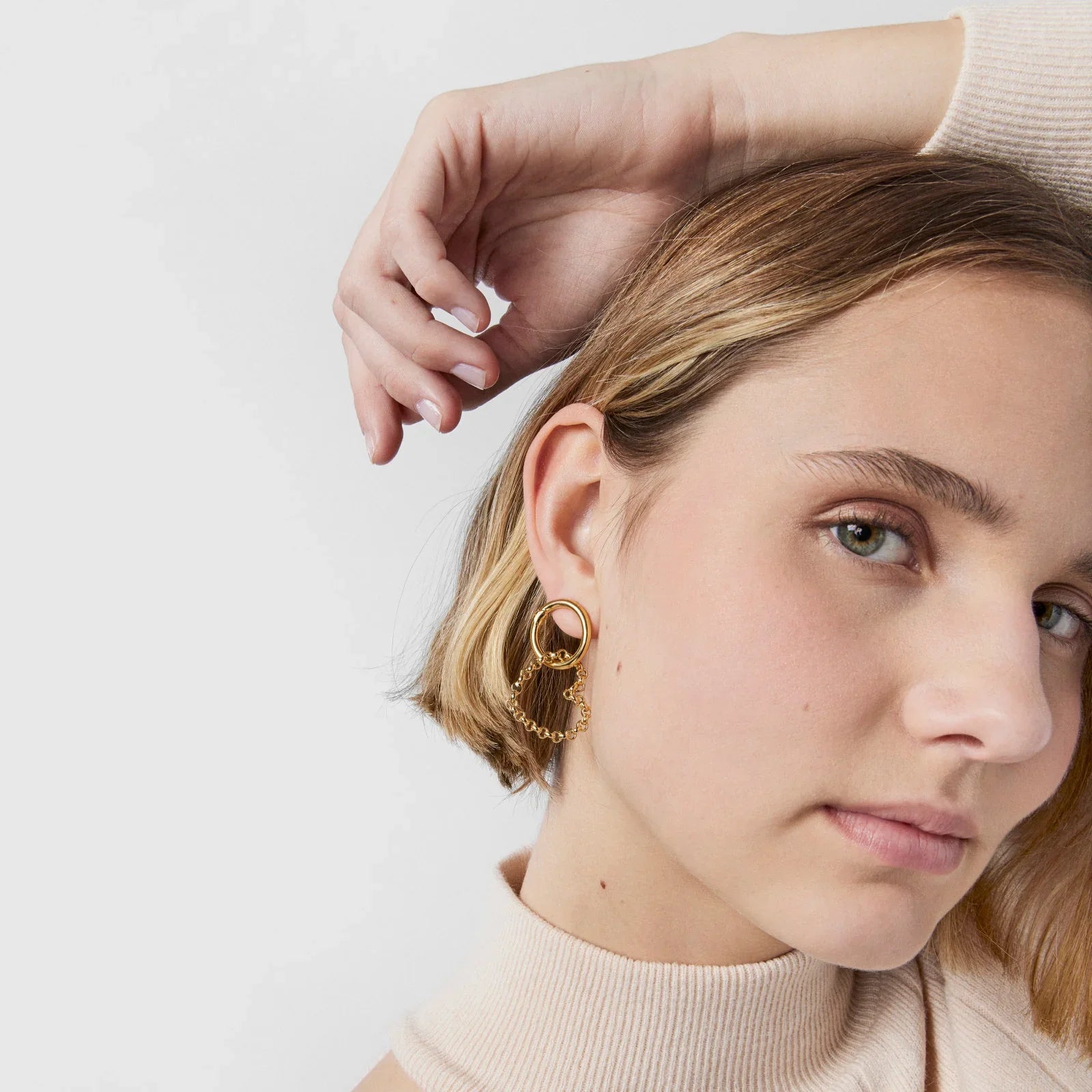 אישה עונדת עגילי זהב אופנתיים, תקריב על פניהם, יוקרה CHOZEN קבוצת אלפא