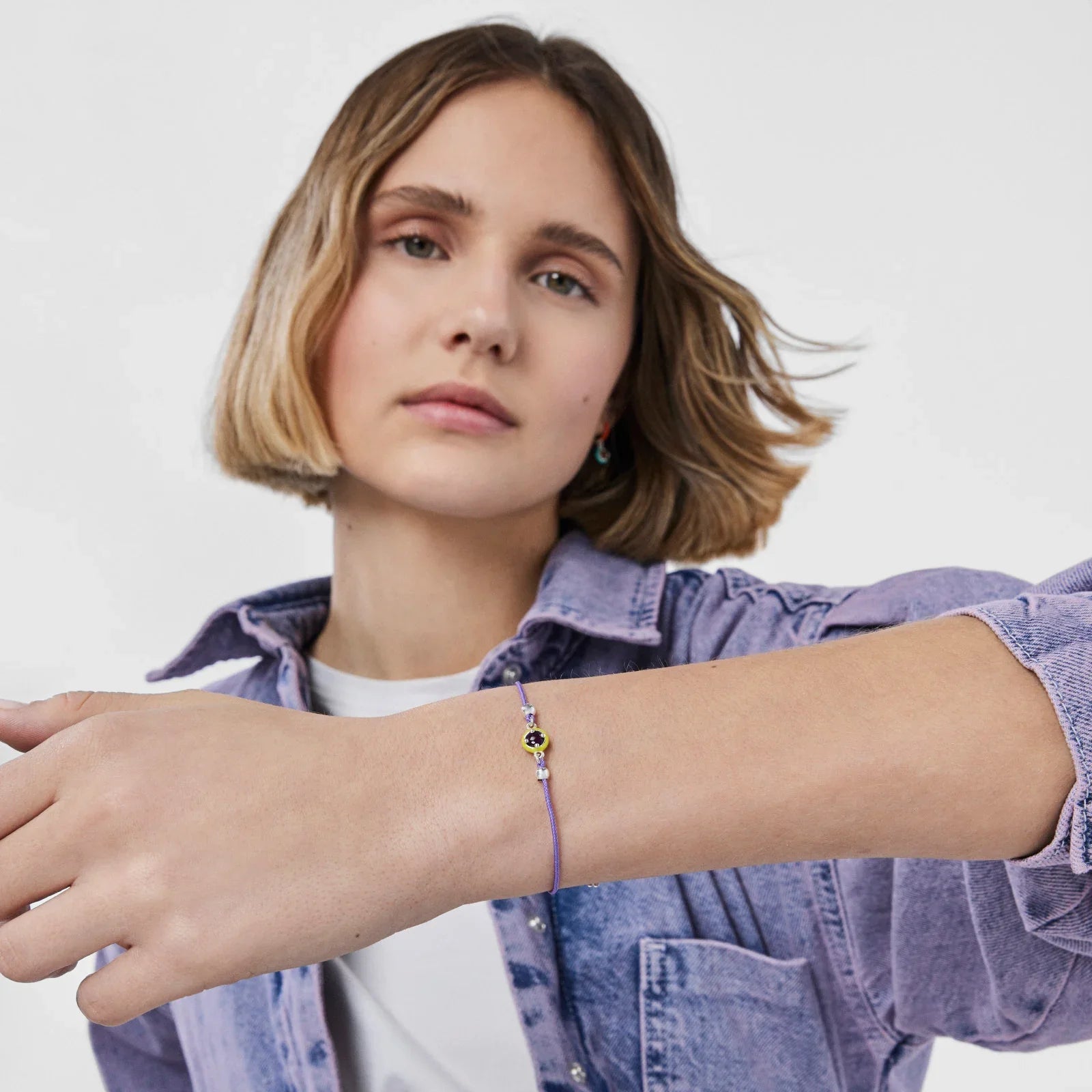 אישה לובשת צמיד עדין סגול ואופנתי, מבית CHOZEN, צילום סטודיו רקע לבן