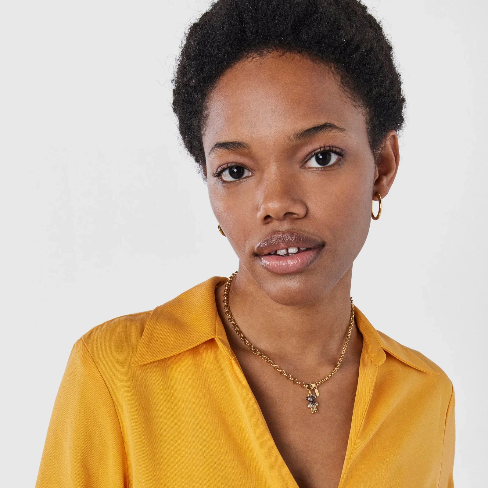 אישה עם חולצה צהובה, עונדת שרשרת זהב ותכשיטים, צילום תדמית CHOZEN