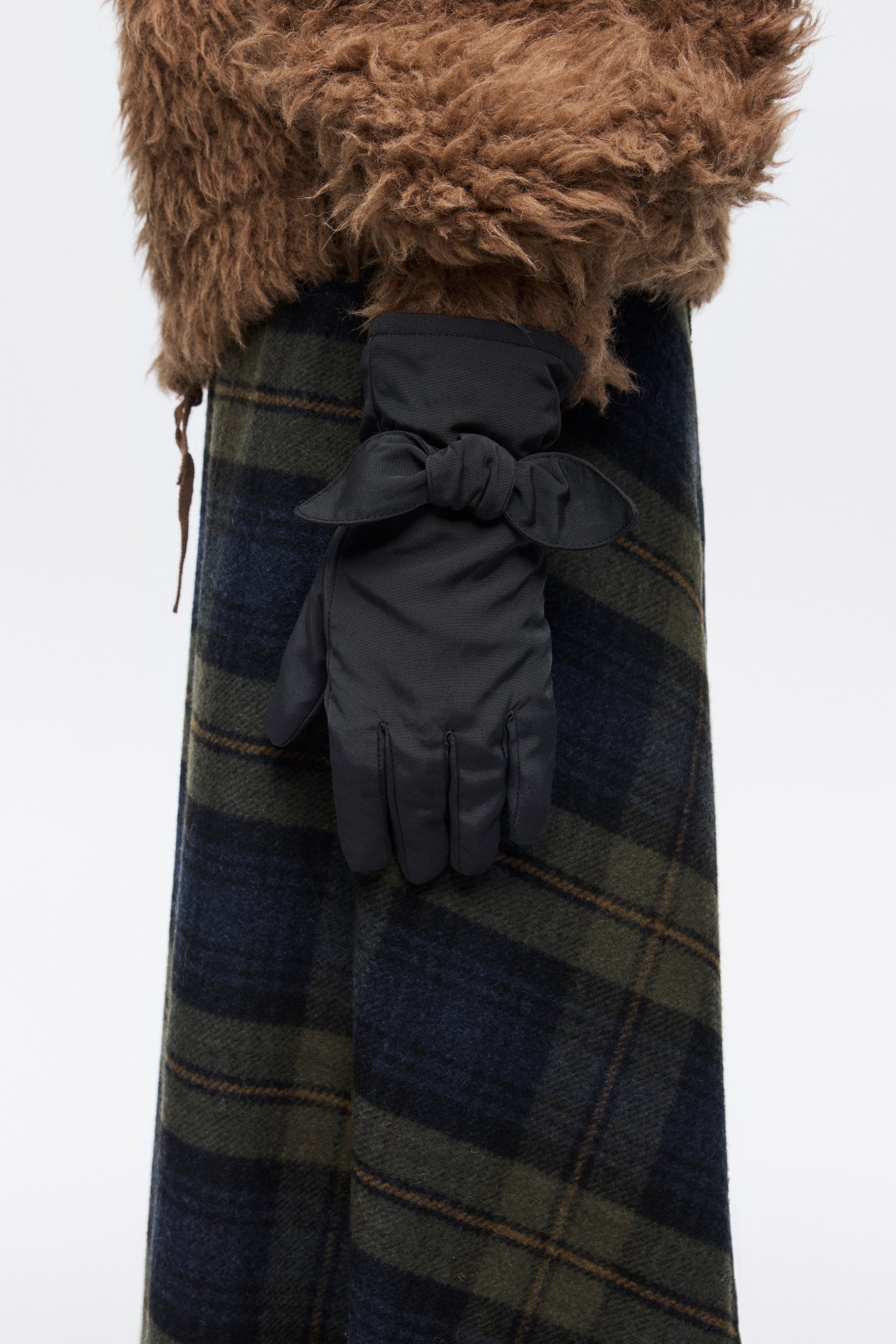 כפפות חורף שחורות עם קישוט קשירה, על מעיל פרוותי וחצאית משובצת, מותג CHOZEN קבוצת אלפא