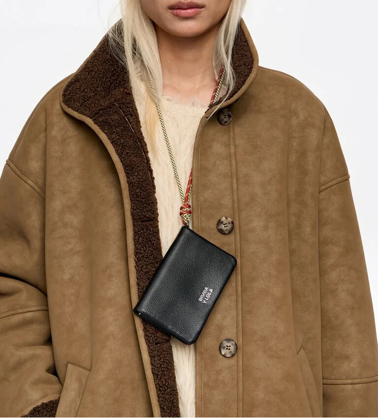 ארנק עור שחור BIMBA Y LOLA על שרוך, נלבש על ידי דוגמנית במעיל חום אופנתי, CHOZEN בגדי מותגים