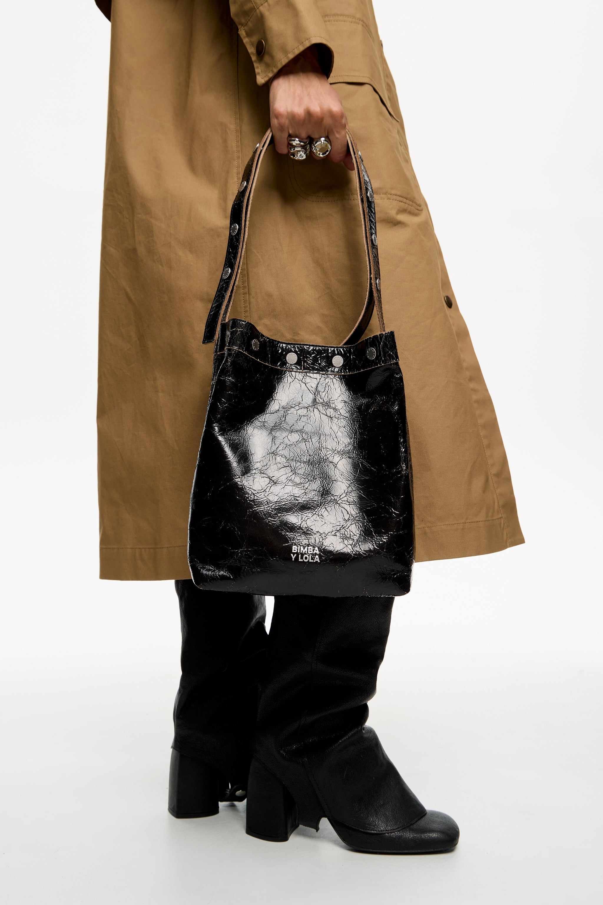 תיק יד שחור של BIMBA Y LOLA, סטייל קלאסי, מוצג עם מעיל חום ומגפיים שחורים ב-CHOZEN
