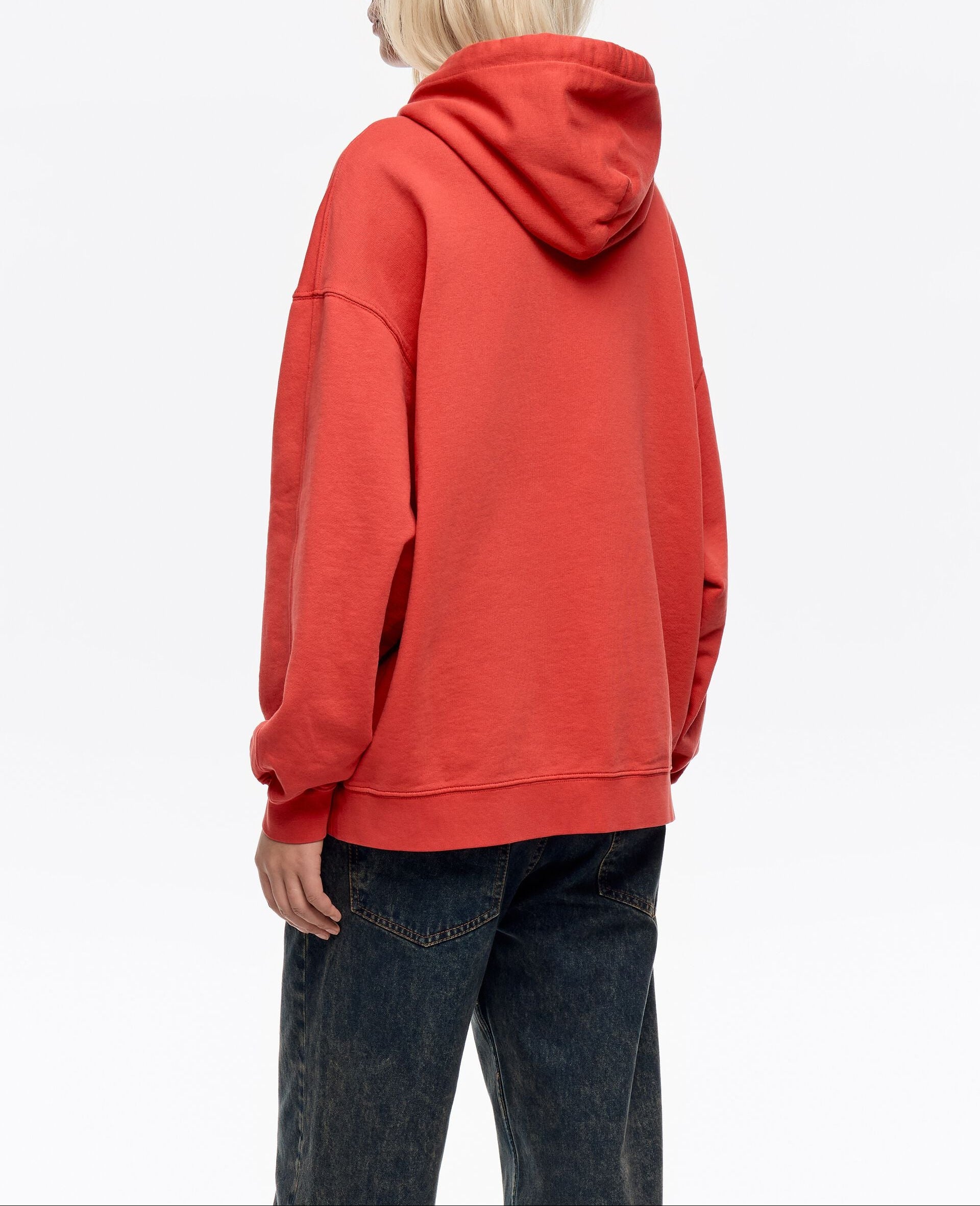 גבר בחולצת קפוצ׳ון אדומה ומכנסי ג׳ינס כהים, צילום מוצר אופנה CHOZEN