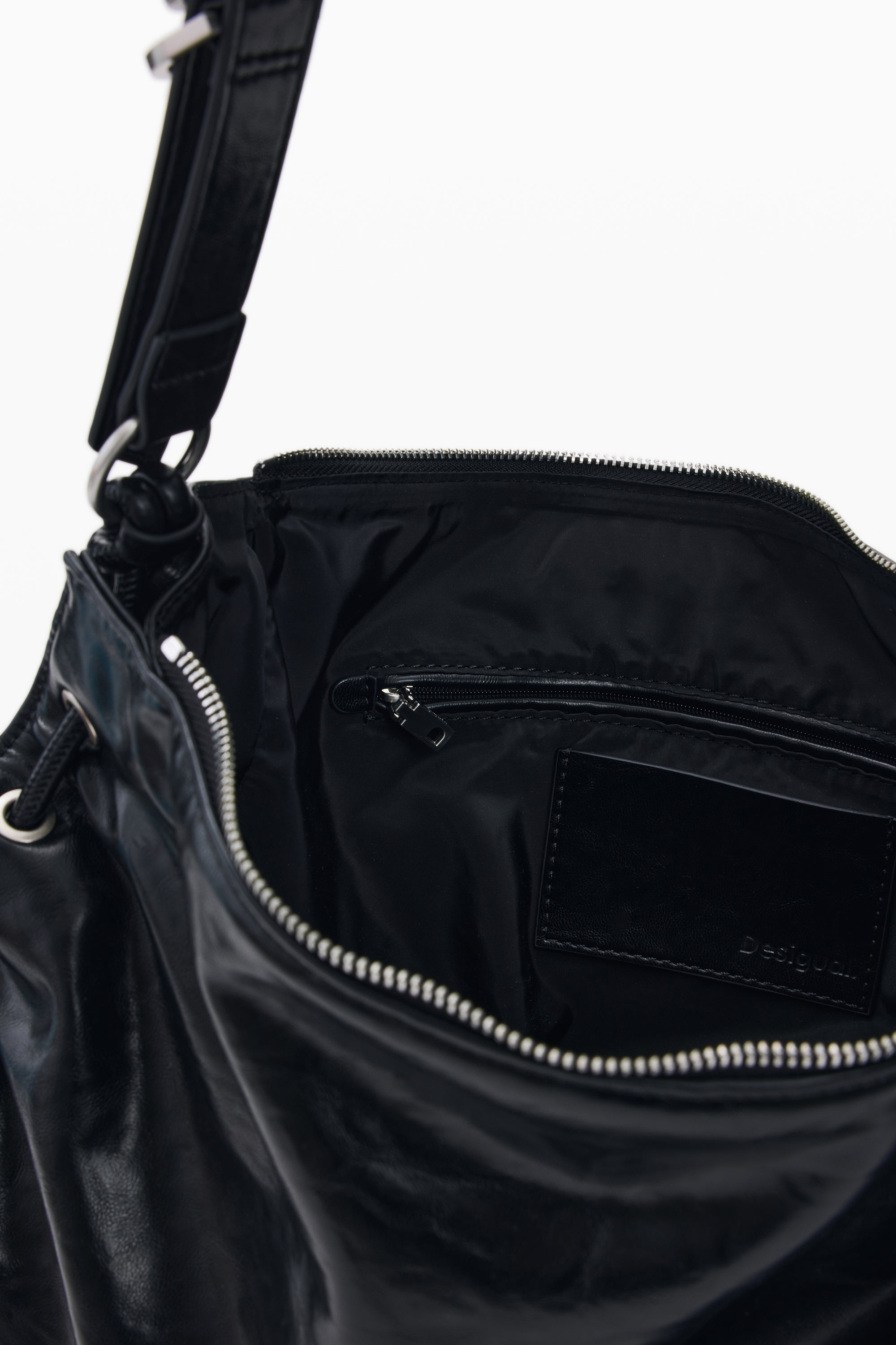 תיק שחור עם רוכסן פתוח, מבט פנימי על תא וכיס קטן, אביזרי אופנה לנשים