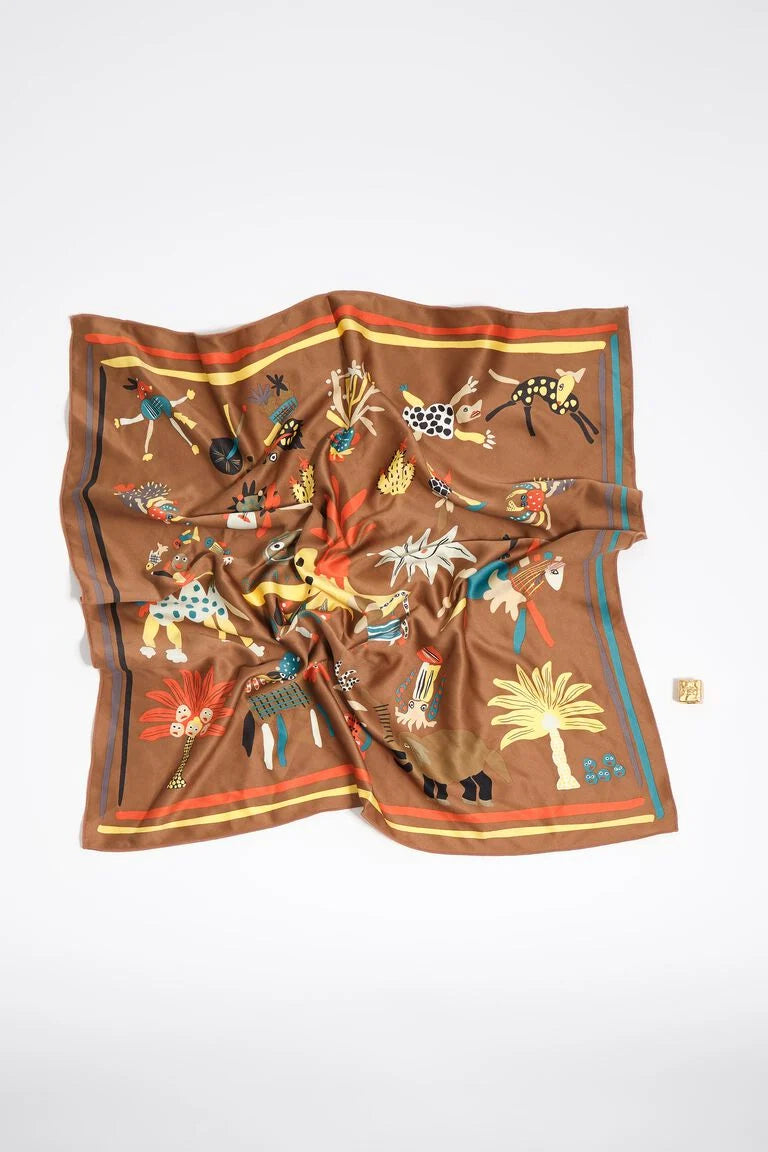 צעיף משי חום עם איורים צבעוניים של בעלי חיים ודקלים, מונח על רקע לבן