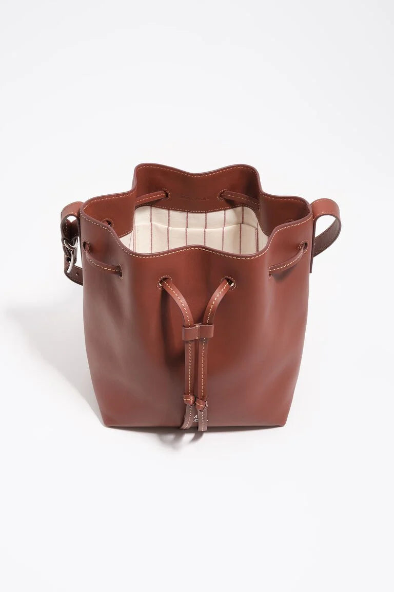 תיק דלי עור חום עם שרוך, עיצוב מודרני, בטנה בהירה מפוספסת, תיק אופנתי לנשים