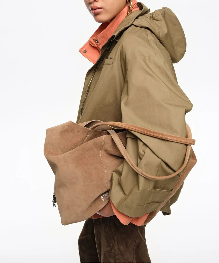 אישה עם מעיל ירוק-חאקי ותיק כתף זמש חום, אופנה עכשווית, רקע לבן