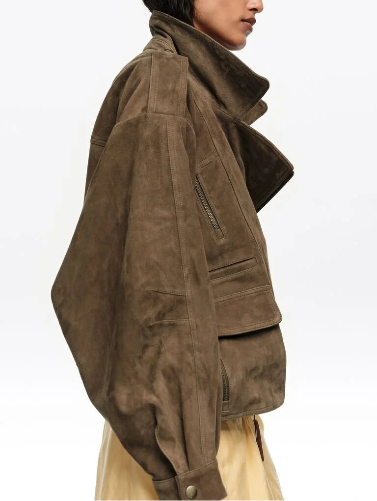 ג׳קט עור חום לאישה עם גזרה רחבה, רוכסנים וכיסים, על דוגמנית בלבוש אופנתי