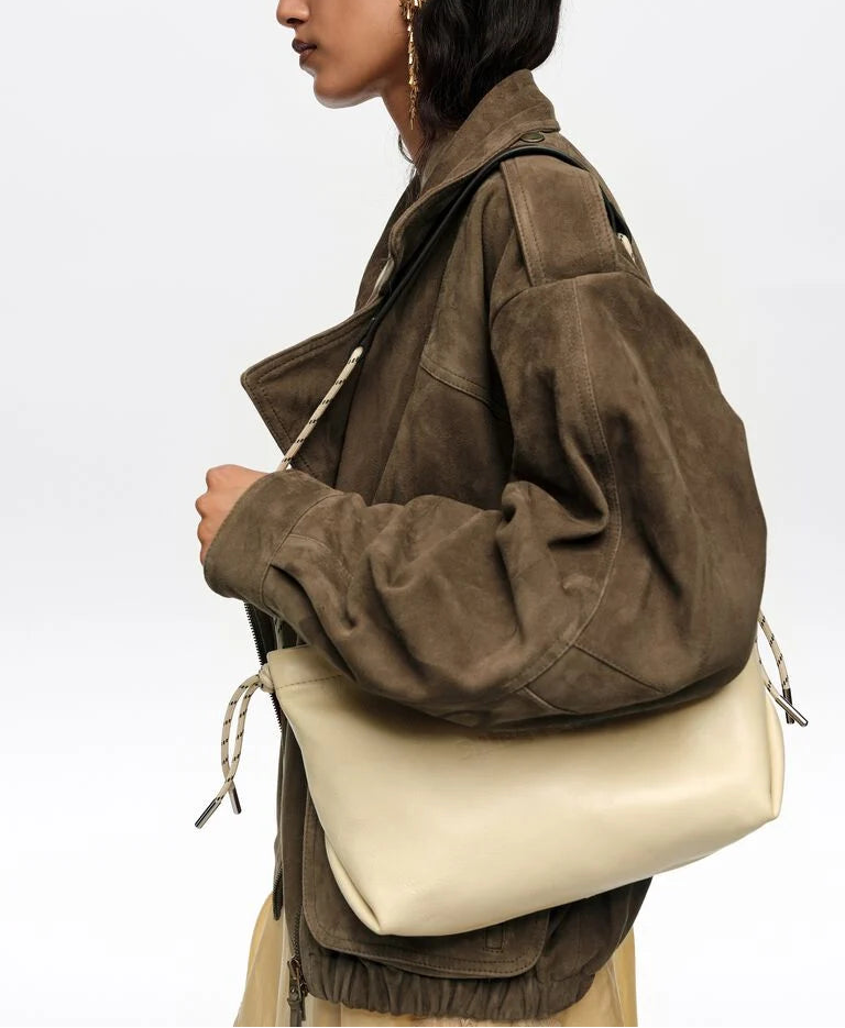 אישה עם מעיל זמש חום ותיק כתף עור בז' אופנתי