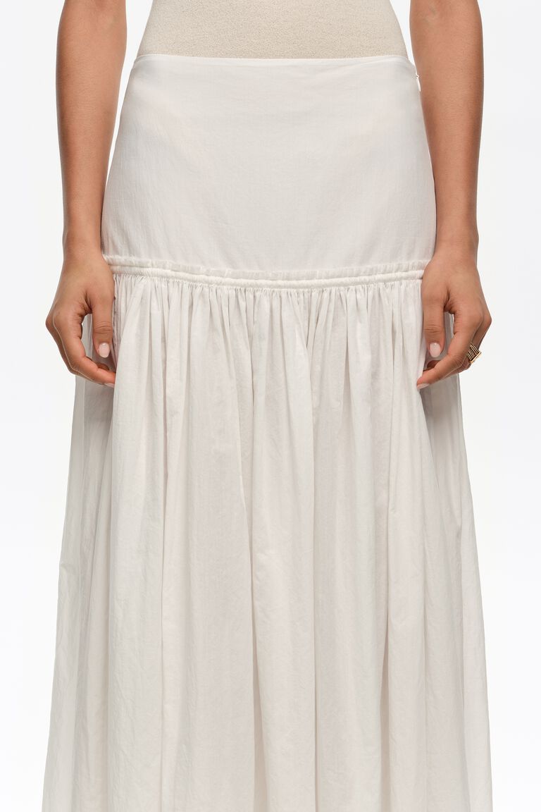 חצאית מקסי לבנה קלאסית, עיצוב קפלים, בד קל ונפול, צילום על דוגמנית
