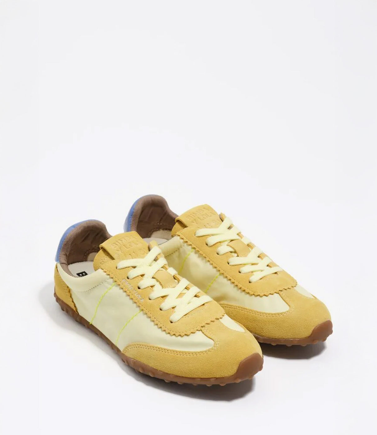 סניקרס נשים בגווני צהוב וקרם בסגנון רטרו, שרוכים וסוליית גומי, צילום על רקע לבן