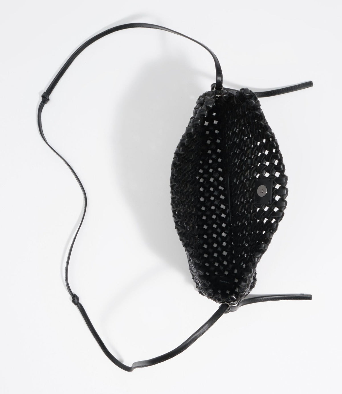 מבט מלמעלה על תיק שחור פתוח עם רצועה מונחת לצדו - CHOZEN