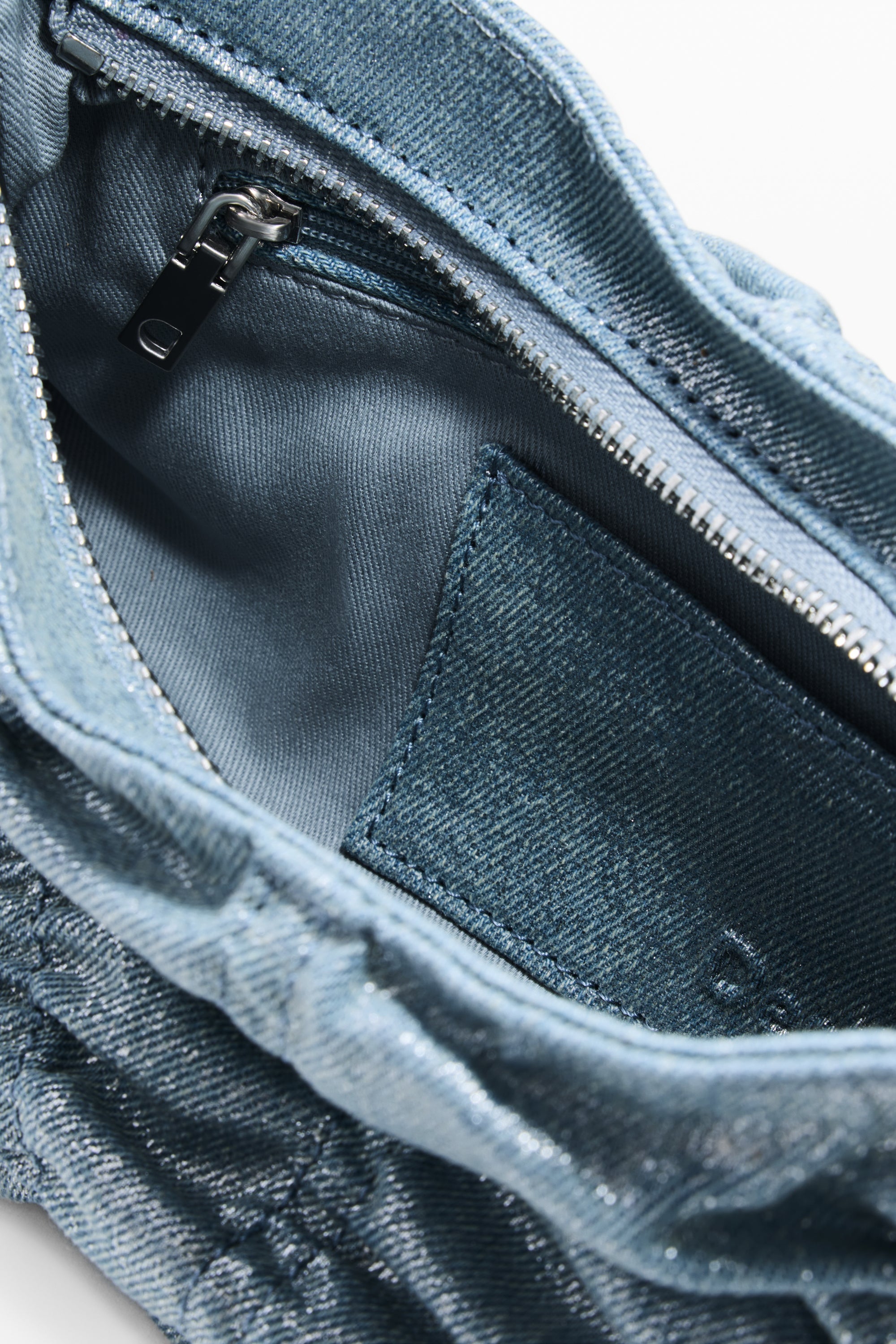 מבט מקרוב על פנים תיק בד ג'ינס כחול עם רוכסן פנימי וכיס בד