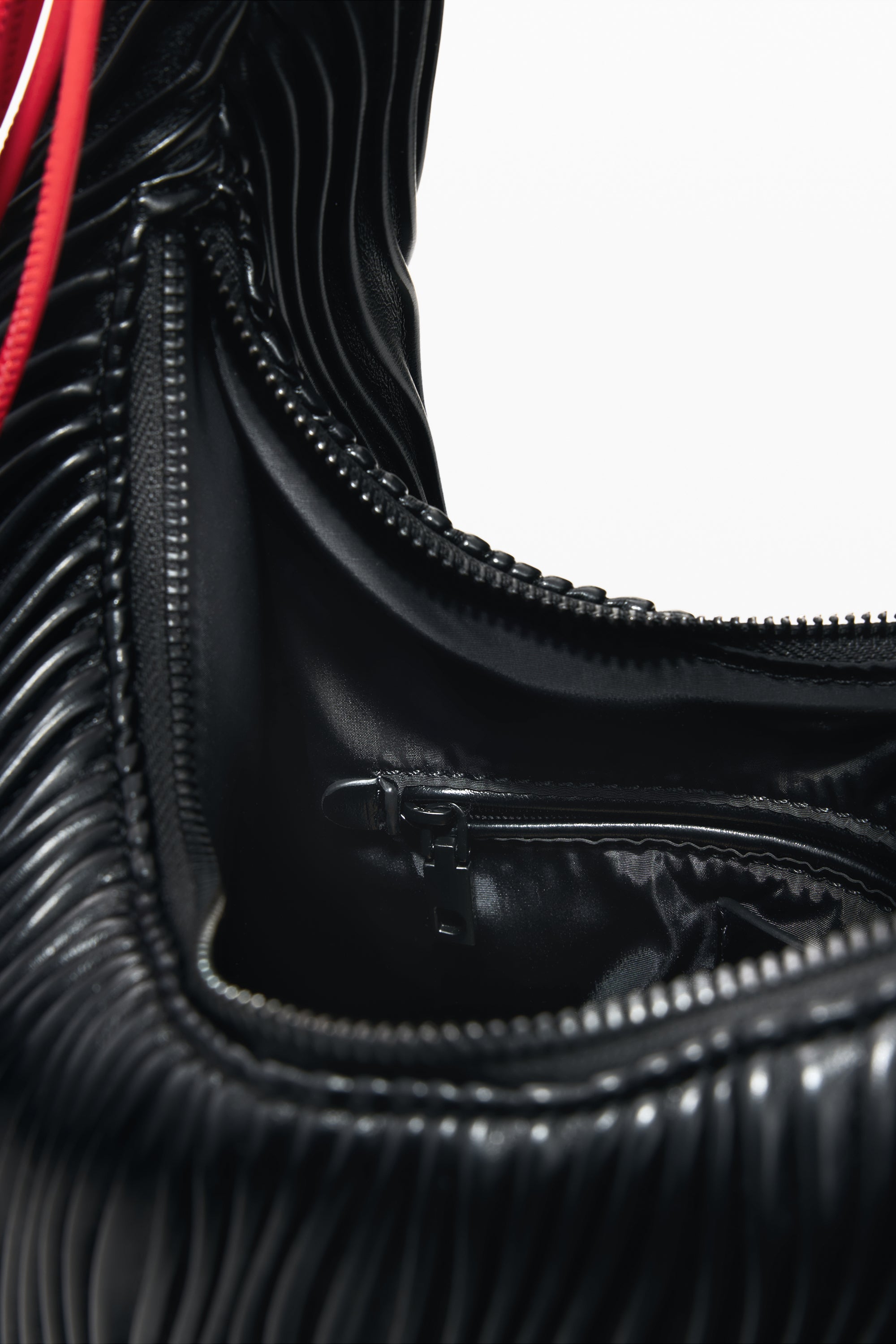 תקריב פנים תיק יד שחור עם רוכסנים, בטנה חלקה ועיצוב קפלים מודרני