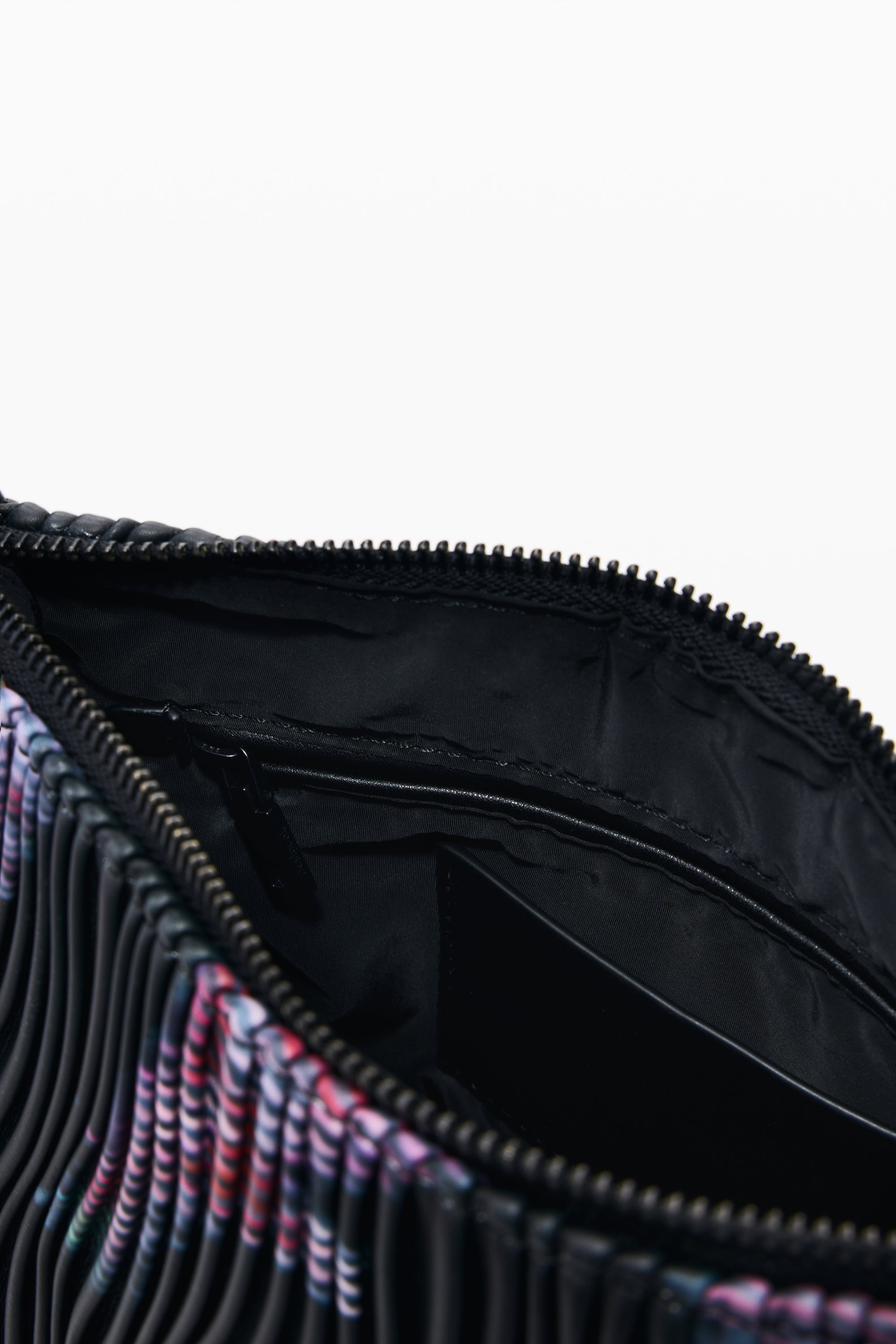 תקריב תא פנימי של תיק אופנתי עם רוכסן, בד שחור ודוגמת פסים צבעונית
