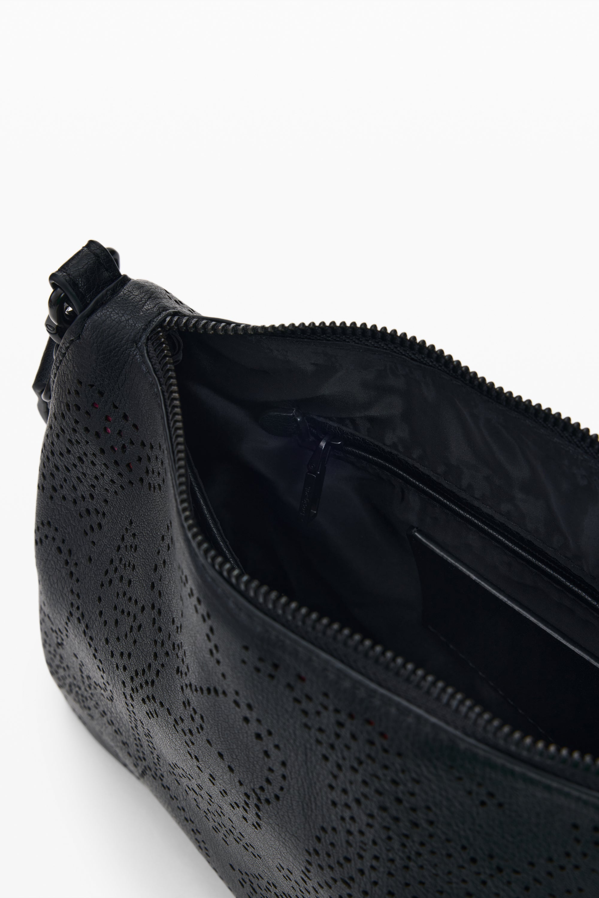 תמונה של פנים תיק קטן שחור עם רוכסן, דוגמת חורים, כיס פנימי וריפוד