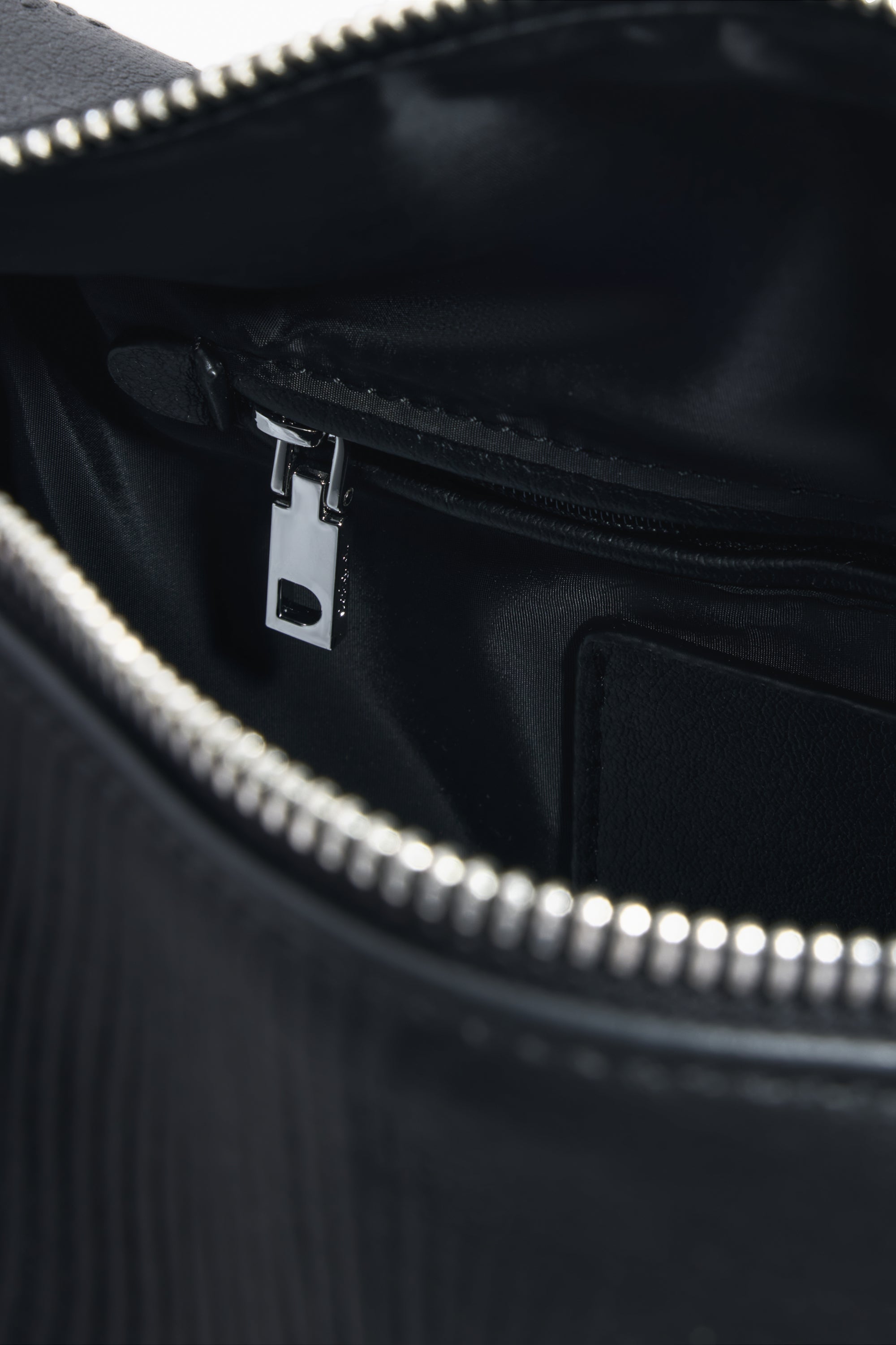 פנים תיק שחור יוקרתי עם רוכסן מתכתי ותא פנימי עם רוכסן