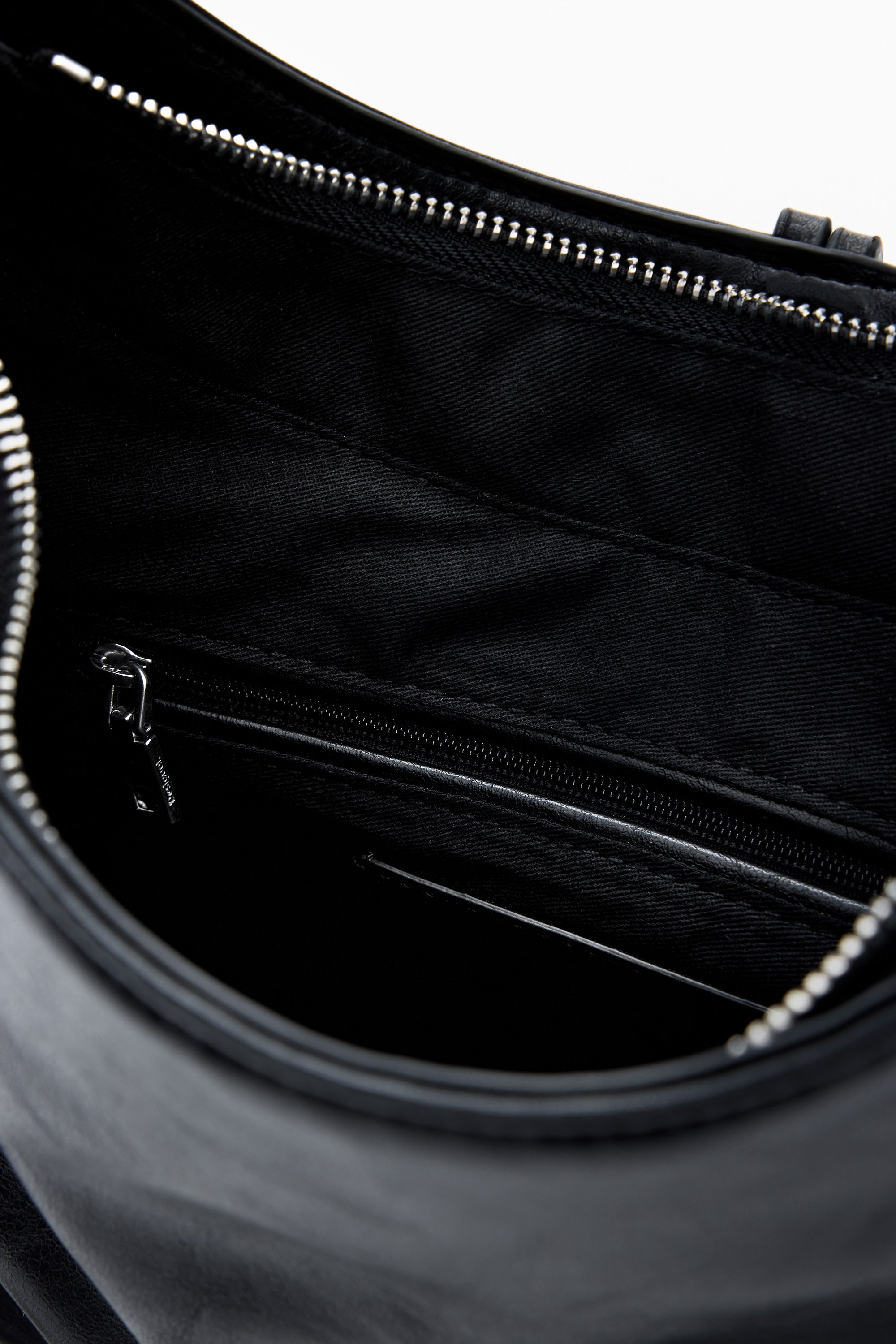 פנים תיק שחור עם בטנה מבד איכותי, כיס פנימי ברוכסן ורכיסת רוכסן עליונה