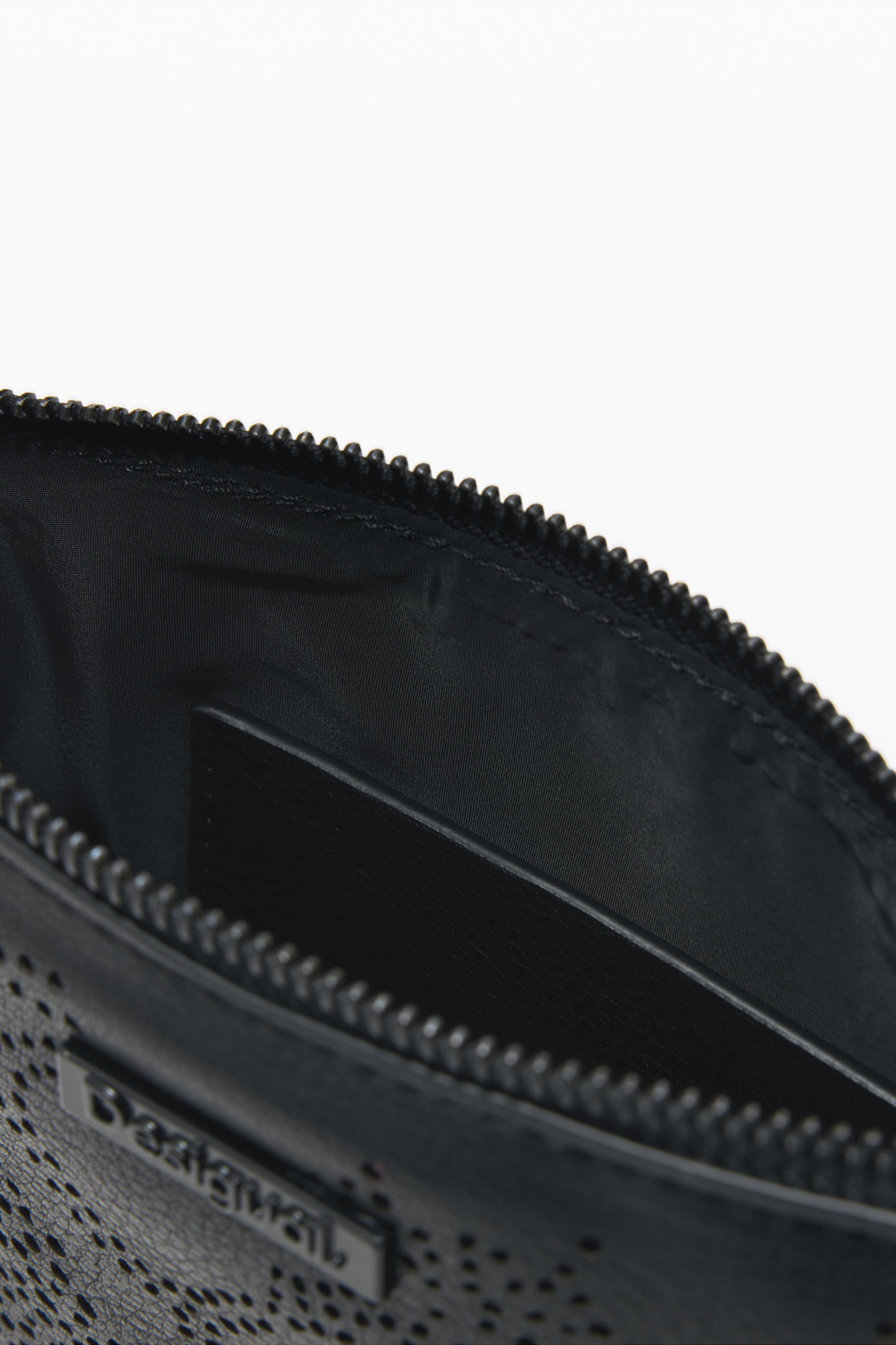 תקריב של ארנק שחור עם רוכסן ותווית מתכת, עיצוב נקבובי מודרני