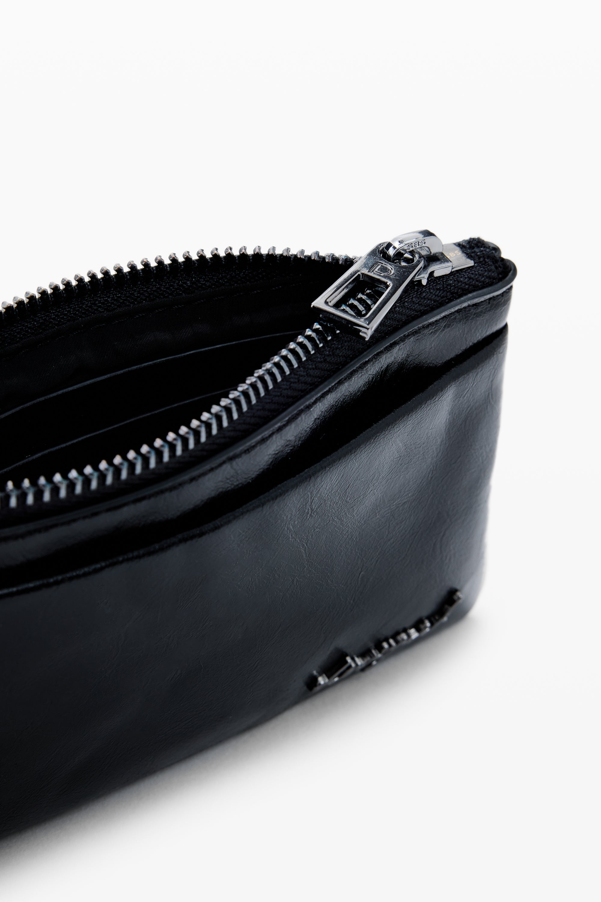 תקריב של ארנק עור שחור עם רוכסן פתוח, עיצוב מודרני, מתאים לאחסון כרטיסים ומטבעות