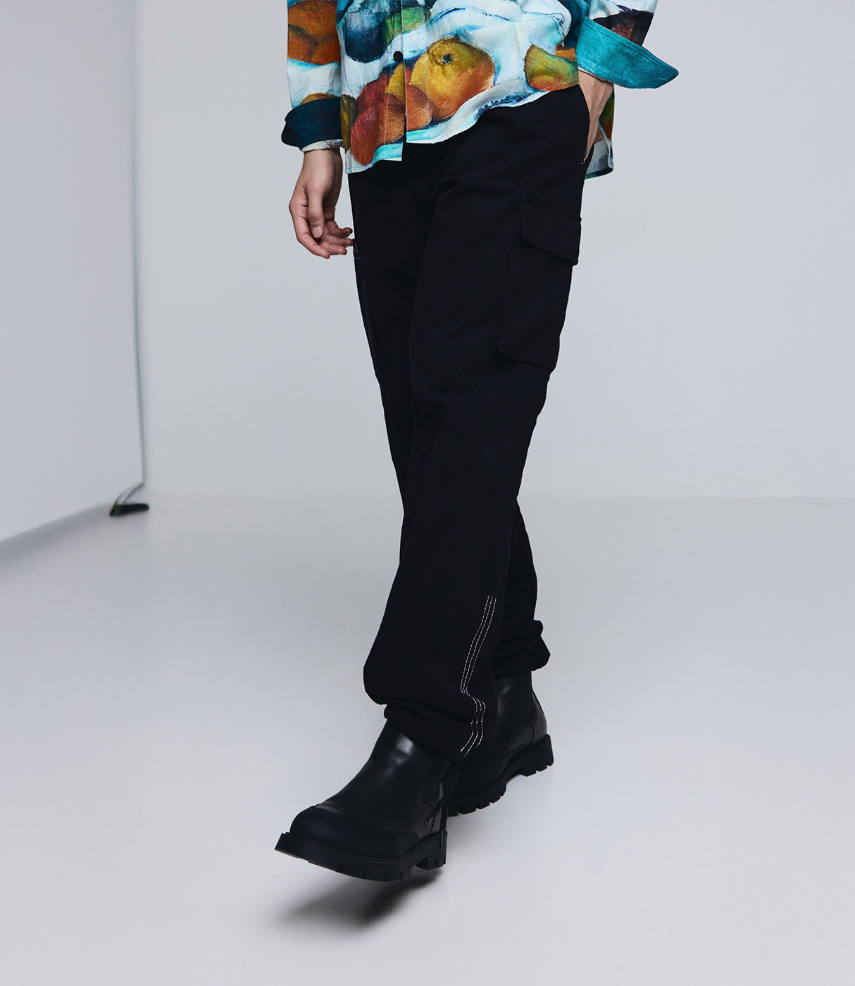 מכנסי קארגו שחורים לגברים עם כיס צד, חולצה צבעונית ונעלי מגף שחורות