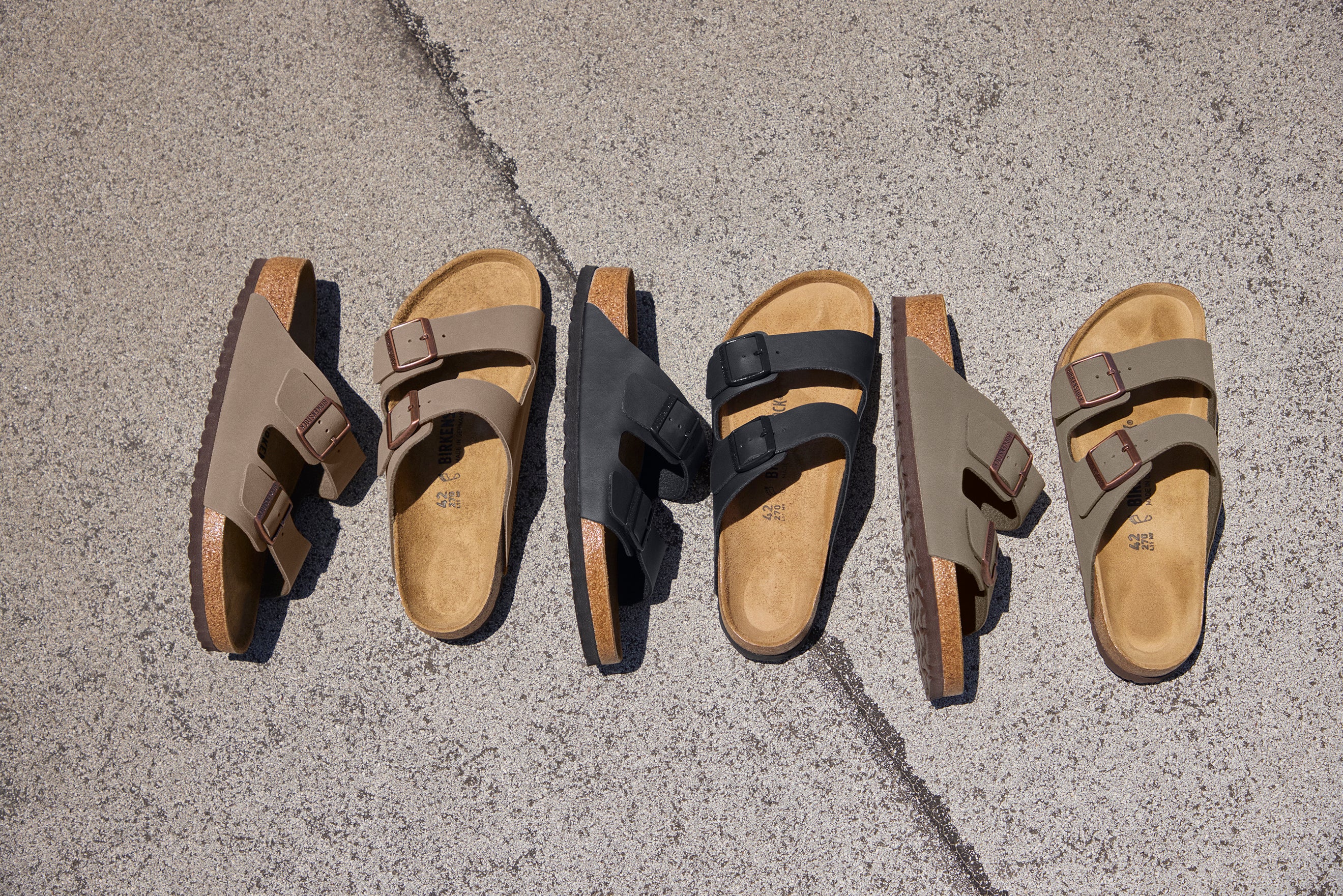 חמישה זוגות סנדלי בריקנסטוק בעיצוב דו-רצועתי על משטח בטון, מבית CHOZEN