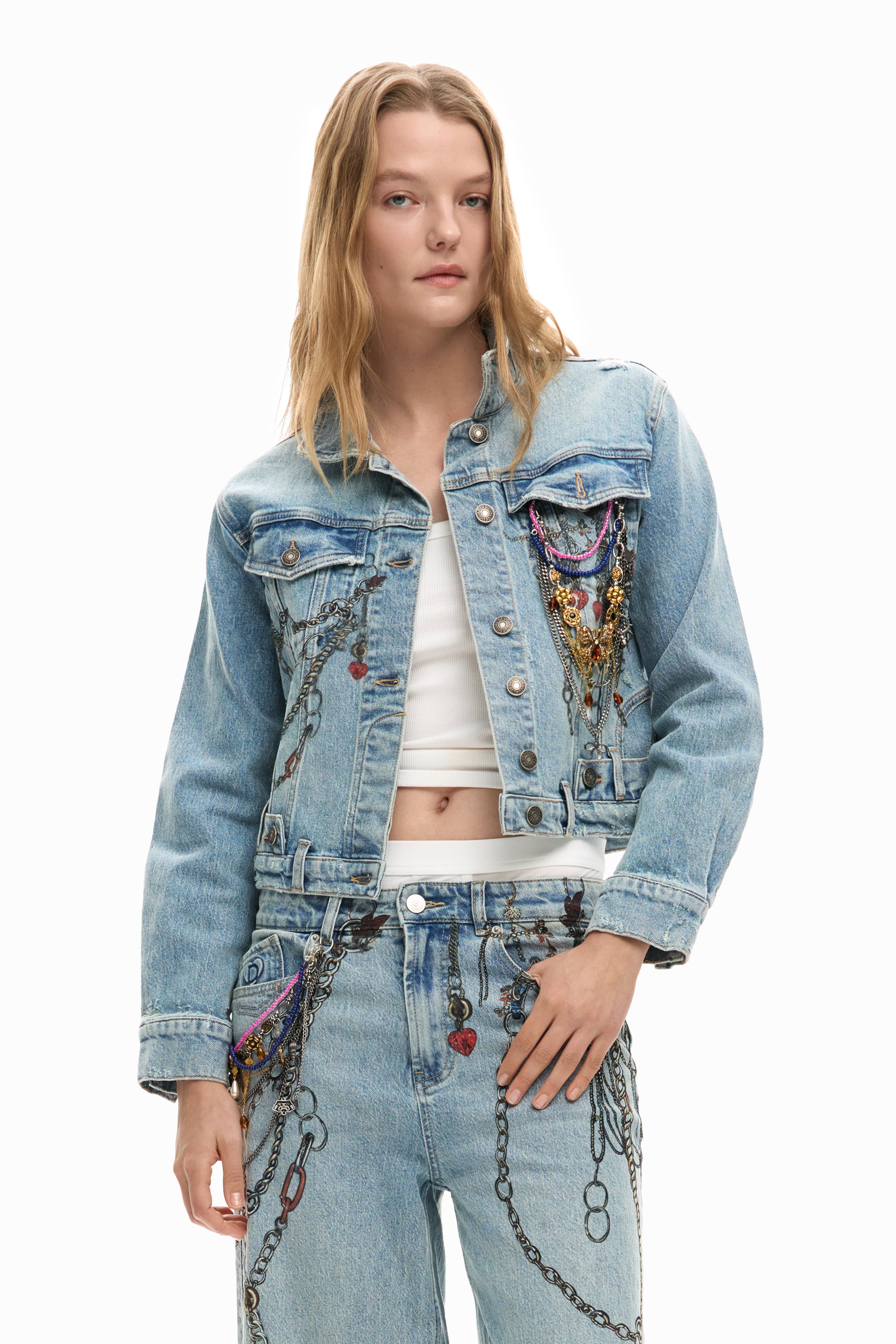 דוגמנית לובשת ג'קט ג'ינס עם קישוטי שרשראות צבעוניים ותיקוני לבבות, אופנה טרנדית לנשים