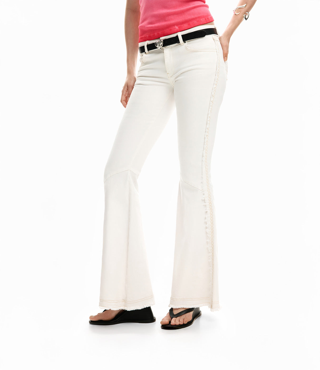 מכנסיים לבנים בגזרה מתרחבת לנשים, חגורה שחורה, חולצה ורודה, סנדלי פלטפורמה