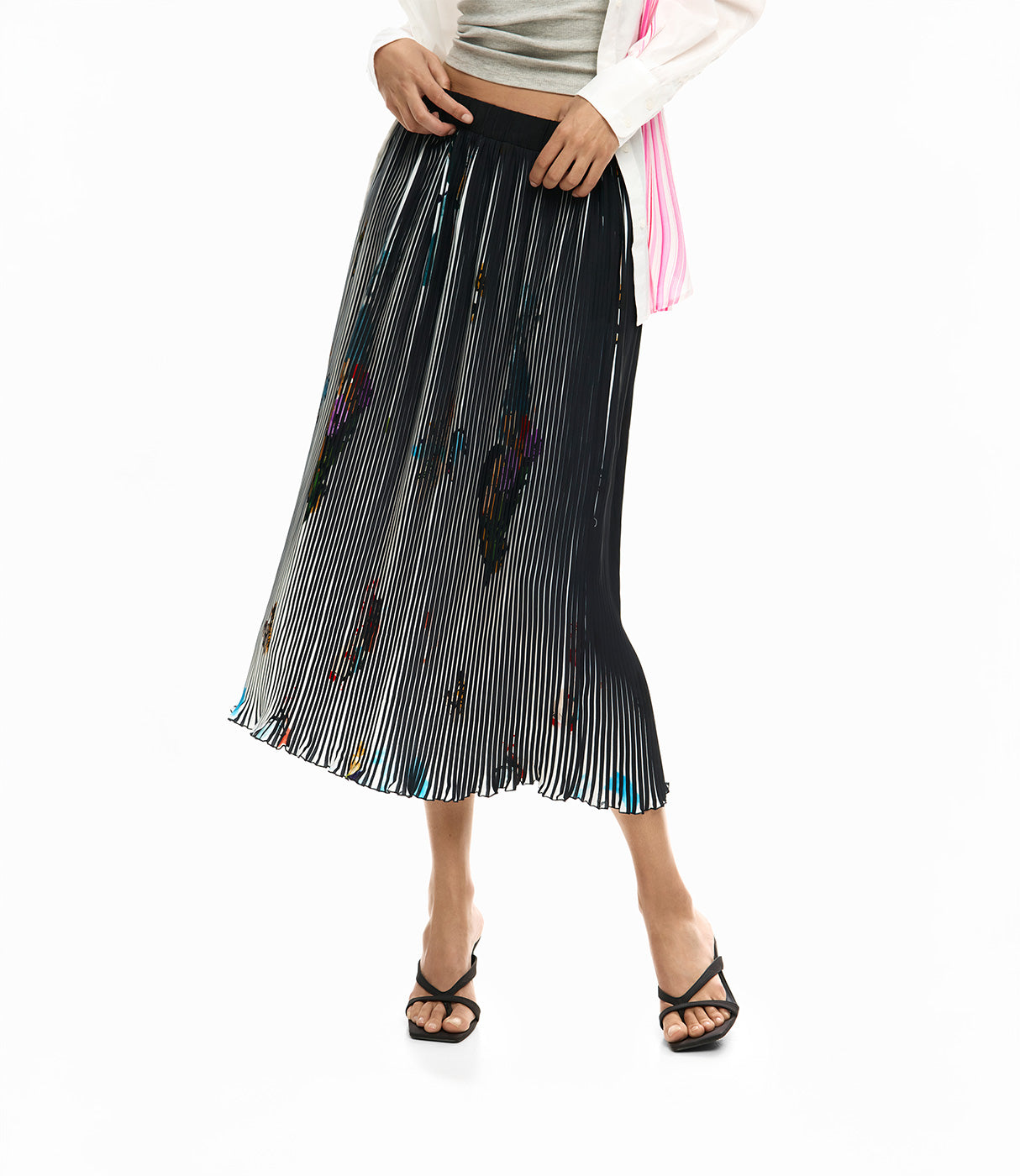 חצאית פליסה שחורה עם הדפס צבעוני בסגנון מודרני, ננעלת עם סנדלים עקב