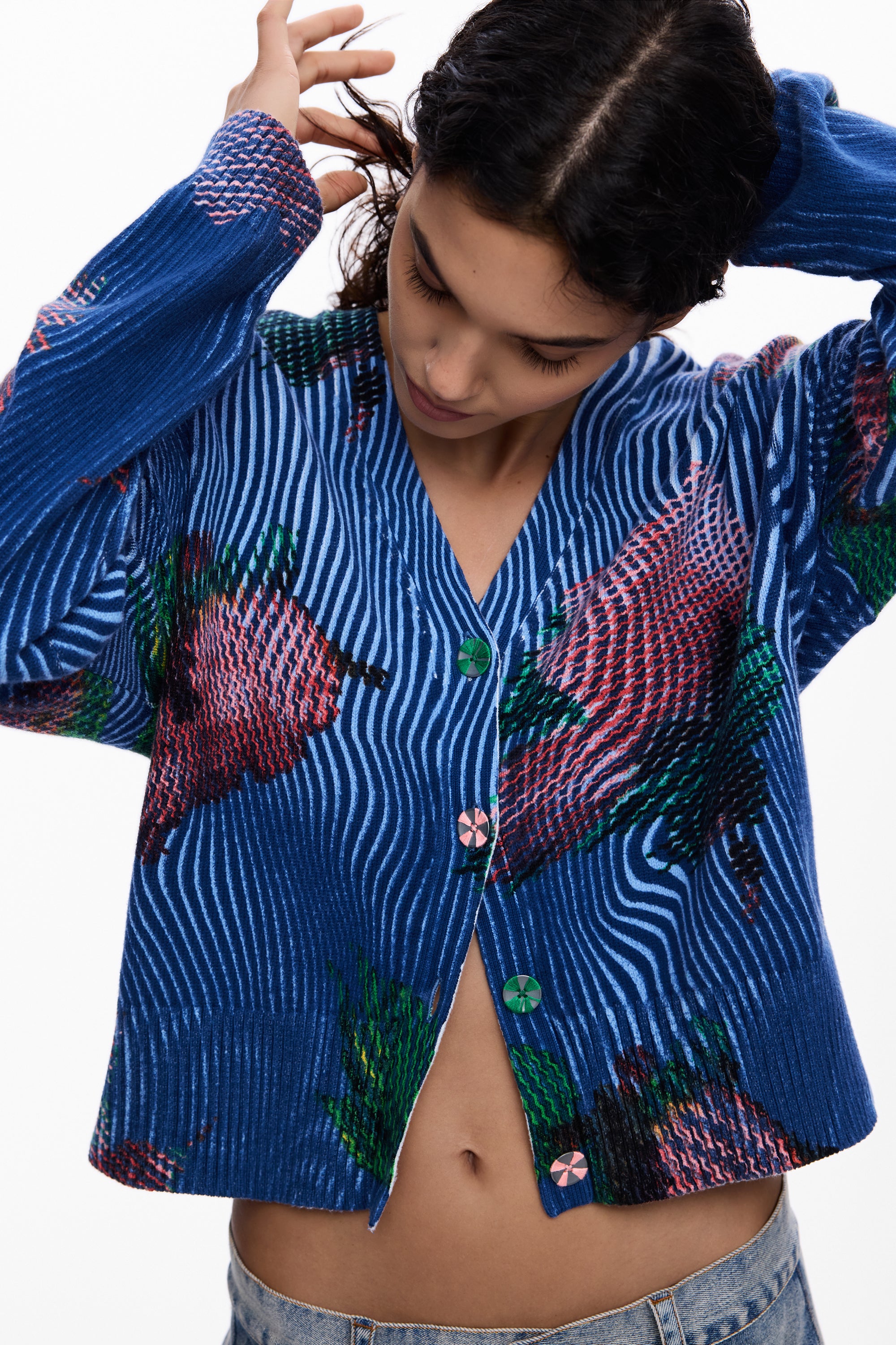 חולצת קרדיגן כחולה עם דוגמת פסים ופרחים צבעוניים על דוגמנית