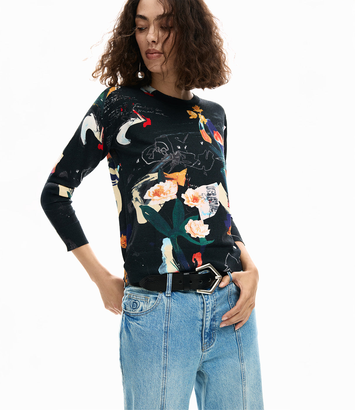 אישה עם חולצת טריקו שחורה בהדפס פרחוני צבעוני ומכנסי ג'ינס, אופנה טרנדית לנשים