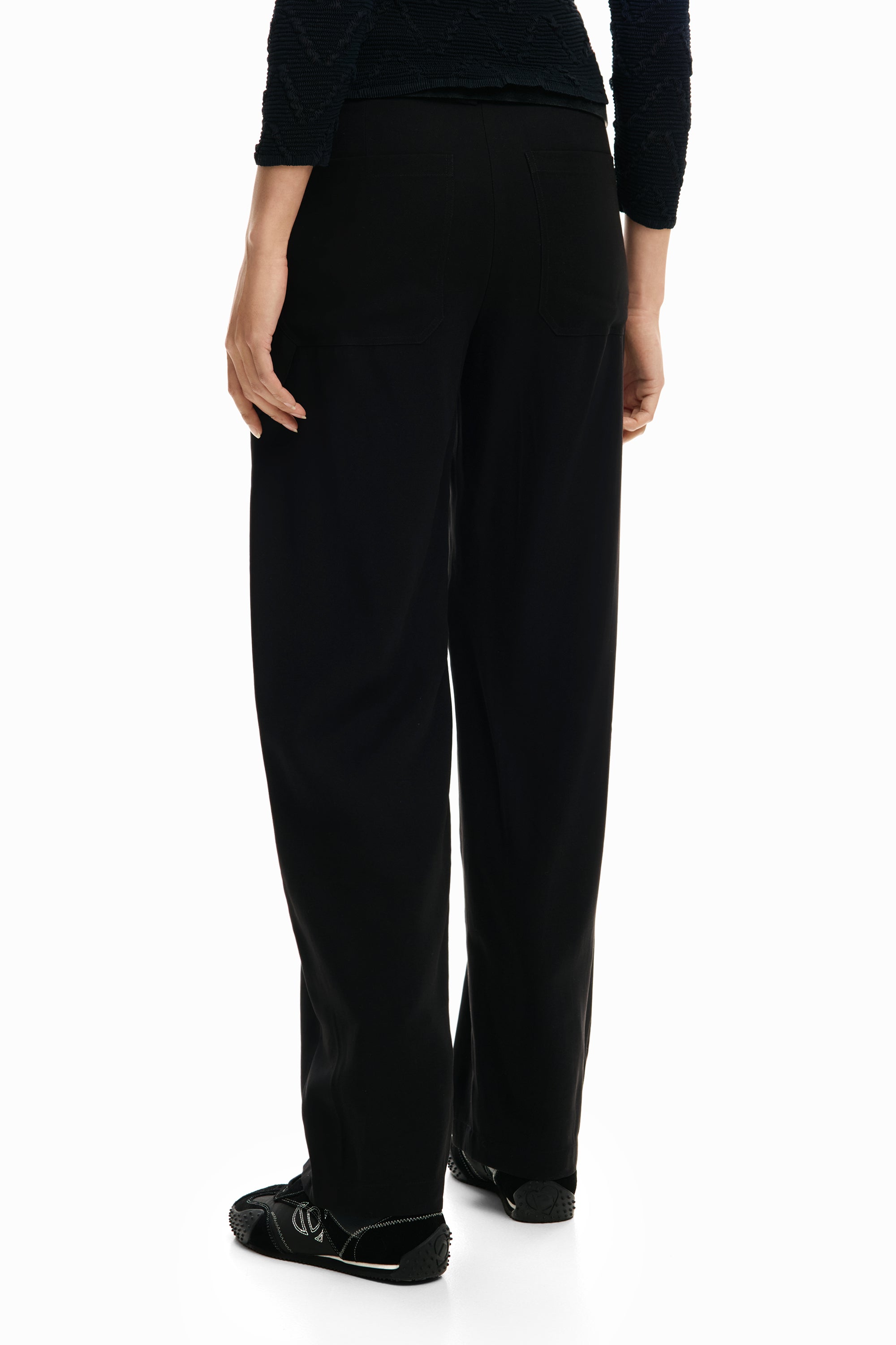 מכנסיים שחורים לנשים בגזרה רחבה עם כיסים אחוריים, מבט מאחור על דוגמנית