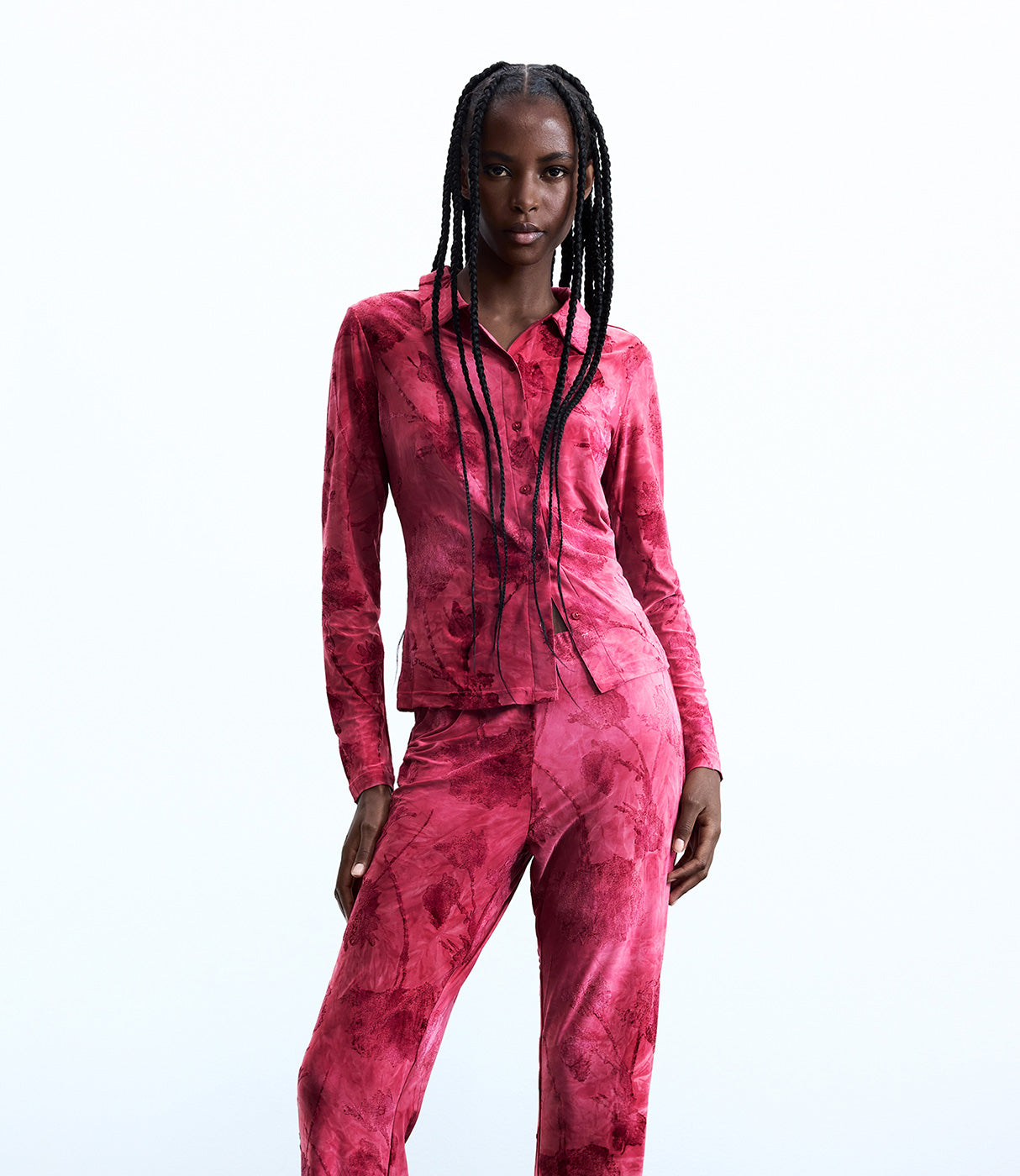 אישה לובשת חליפה ורודה עם הדפס ייחודי, חולצה מכופתרת ומכנסיים תואמים, אופנת נשים עדכנית