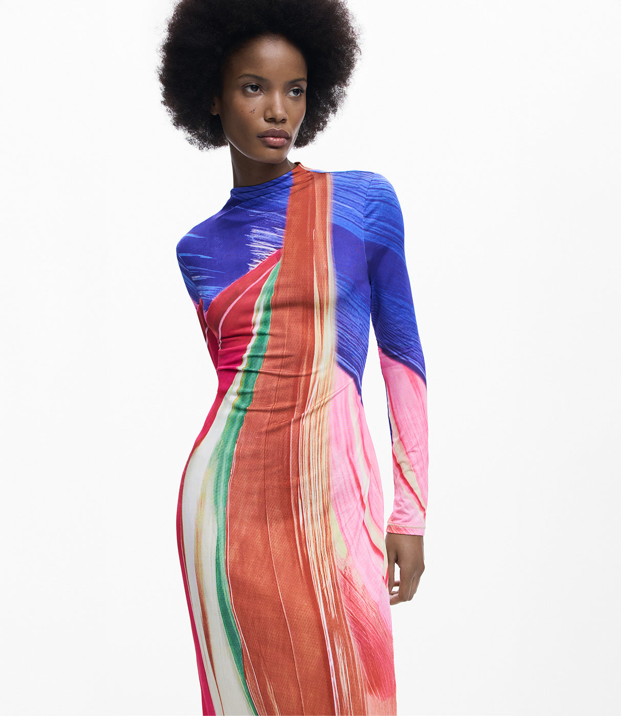 אישה לובשת שמלת מקסי צמודה עם שרוולים ארוכים בהדפס צבעוני מופשט בגווני כחול, אדום, ירוק וורוד