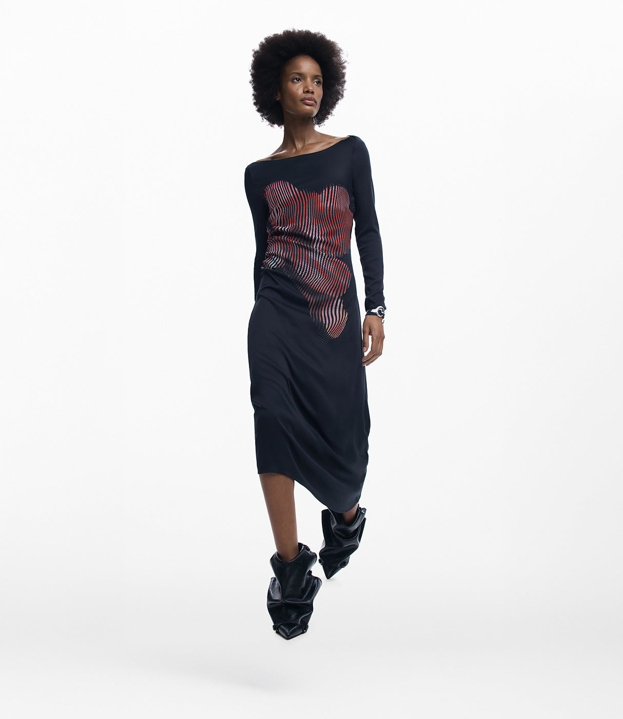 אישה לובשת שמלה שחורה עם שרוולים ארוכים ודוגמת פסים אדומים בחזית, צילום אופנה בסטודיו