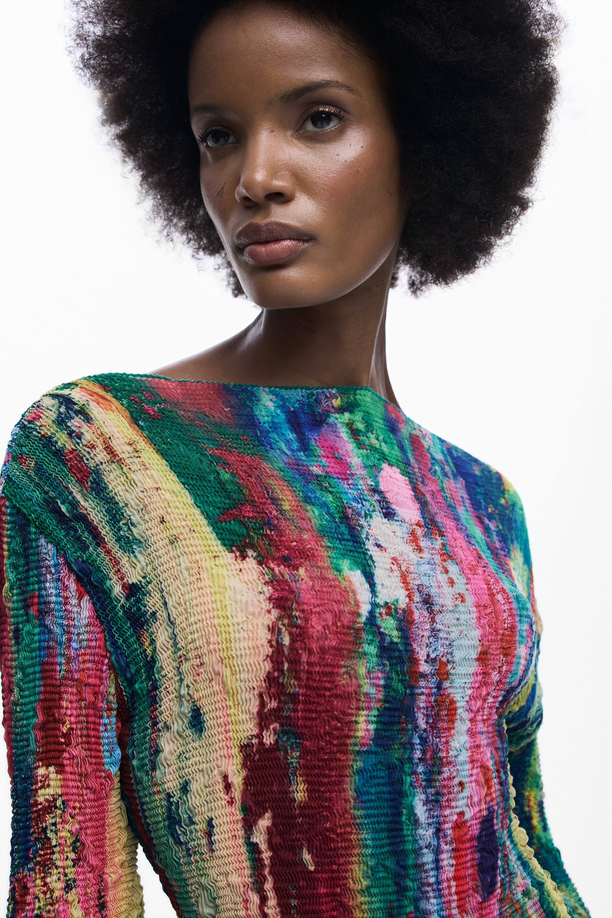 דוגמנית לובשת חולצה צבעונית עם מרקם בד ייחודי, רקע לבן, אופנה מודרנית לנשים