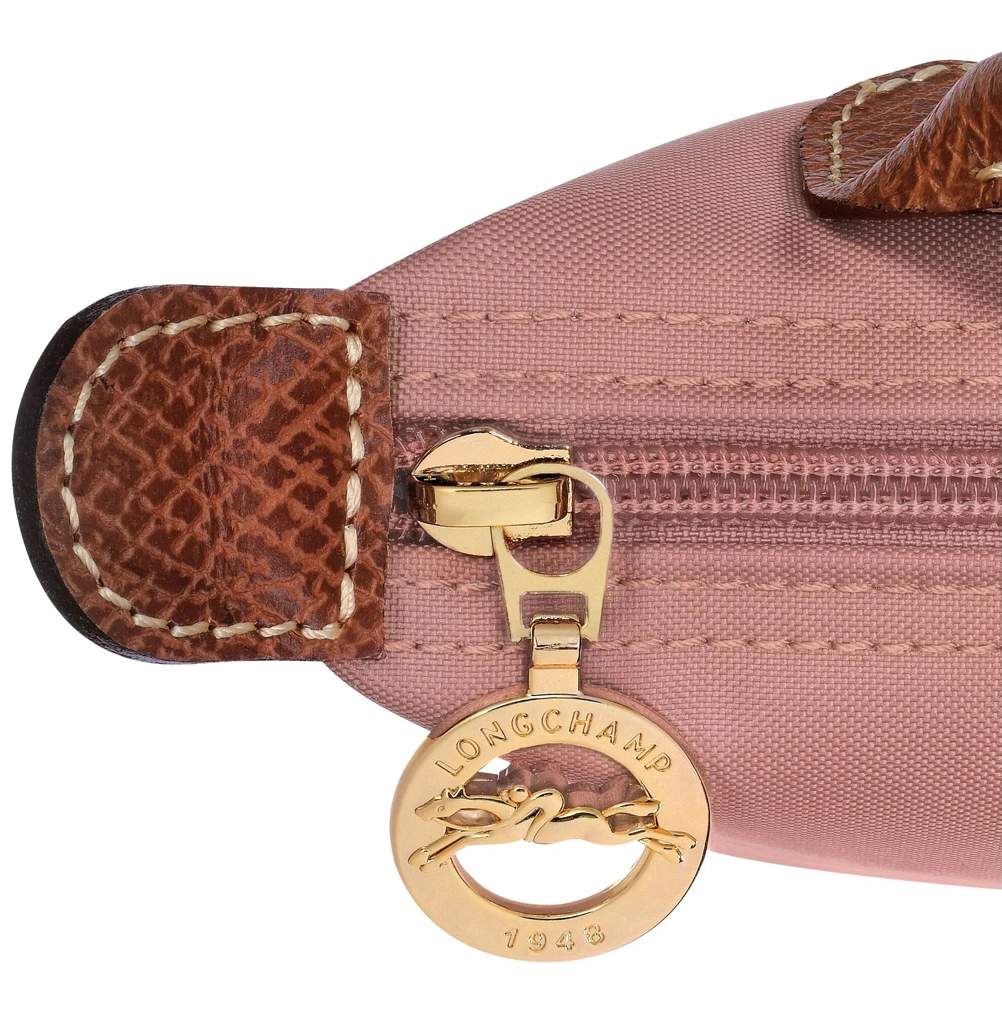רוכסן זהב עם תגית לונגשאמפ על תיק ורוד עם עיטורי עור חום, מותג יוקרה מקבוצת אלפא