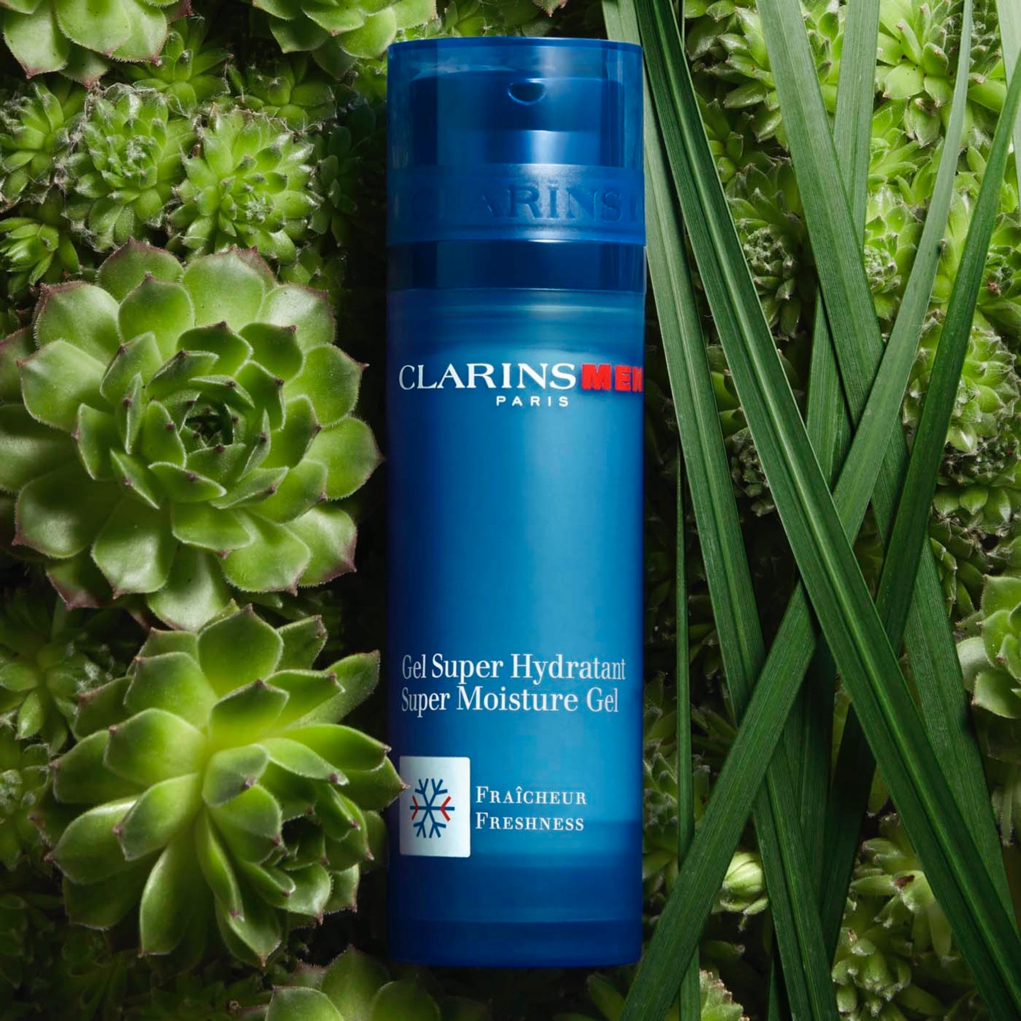 ג'ל לחות לגברים Clarins Men מוצב על רקע צמחים ירוקים, מוצר טיפוח ולעור פנים