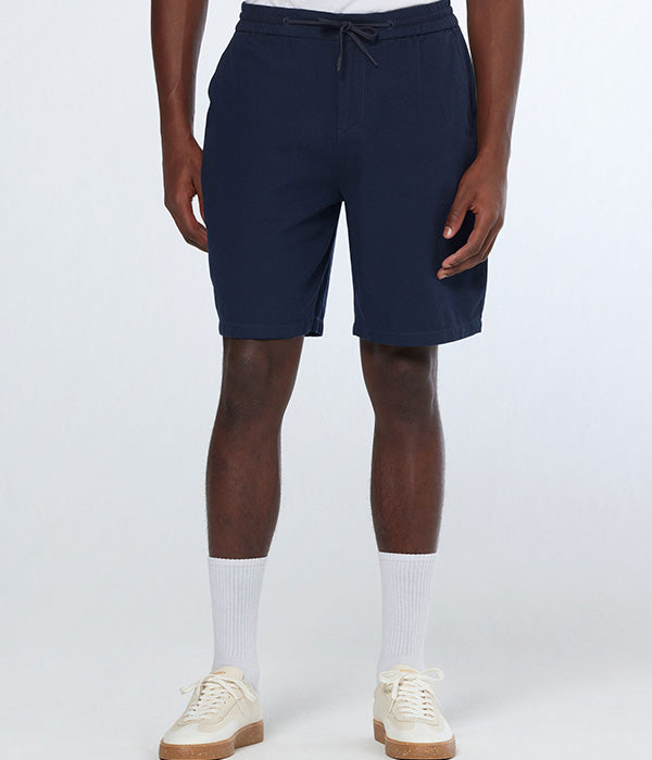 גבר לובש מכנסיים קצרים כחולים, גרביים לבנים ונעלי ספורט, רקע סטודיו, CHOZEN