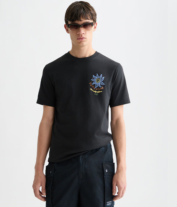 דוגמן בחולצת טי שחורה עם הדפס גרפי, משקפי שמש, רקע לבן, CHOZEN מותגים מובילים