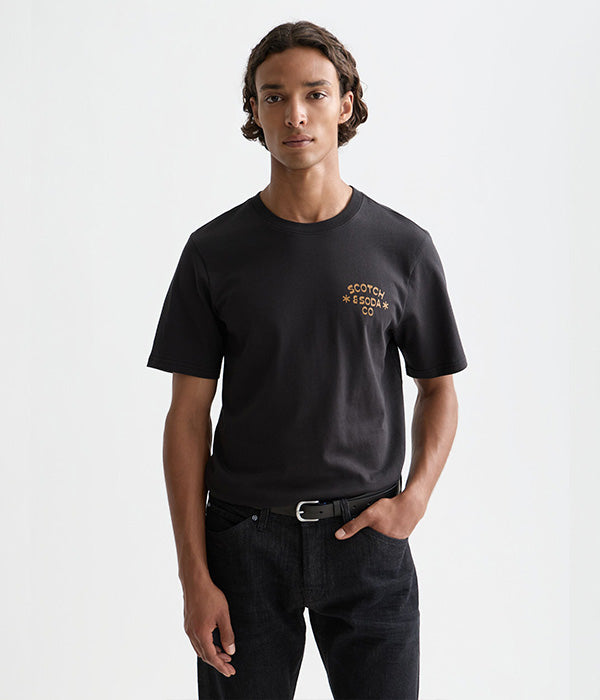 גבר לובש חולצת טי שחורה עם כיתוב SCOTCH & SODA CO, אופנה לגברים מבית CHOZEN