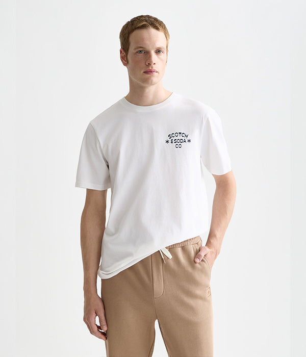 גבר לובש חולצת טי לבנה עם כיתוב SCOTCH & SODA ומכנסי טרנינג בז' בסגנון אופנתי, CHOZEN