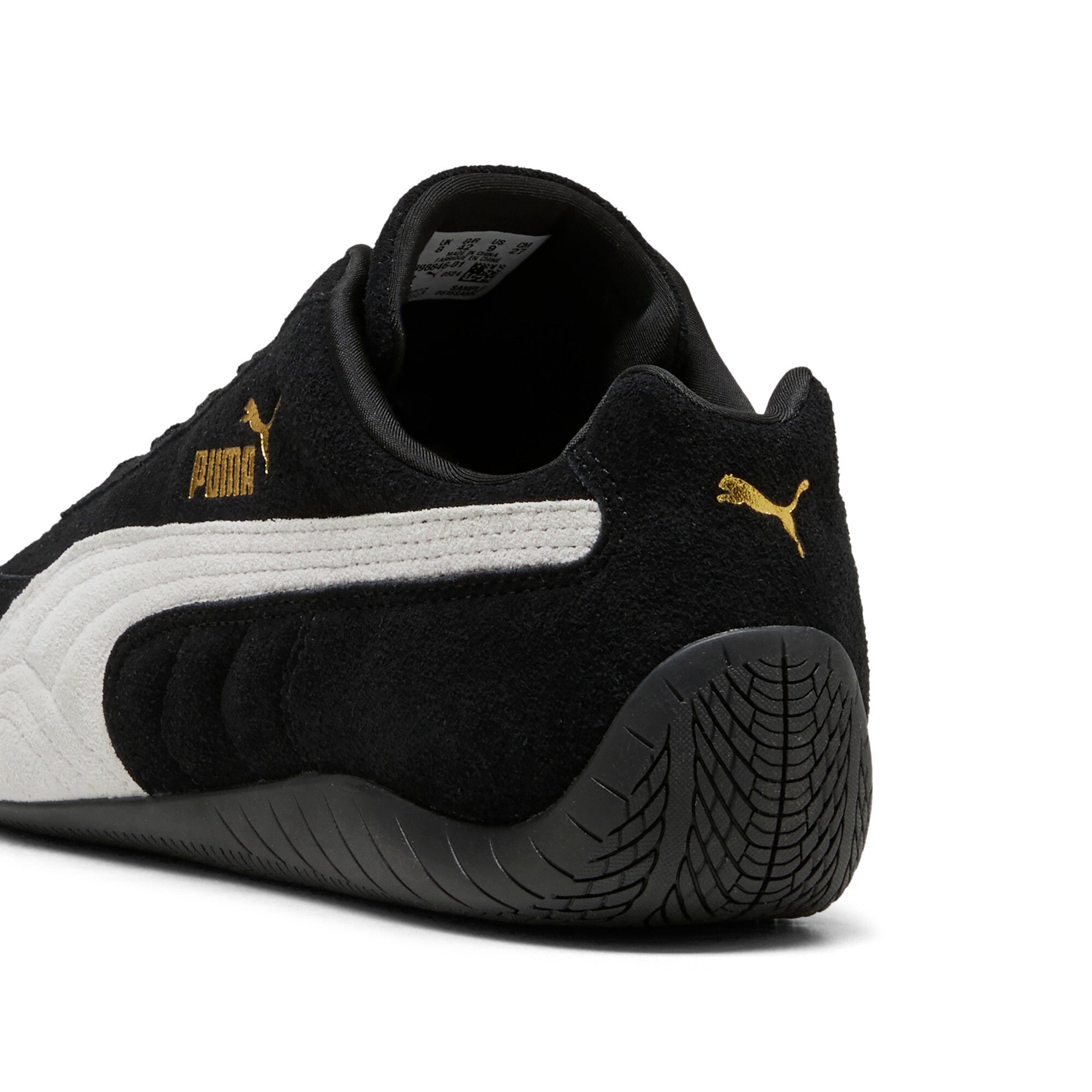 נעל ספורט שחורה עם סוליה שחורה, לוגו Puma זהוב ופסים לבנים, מבט מאחור