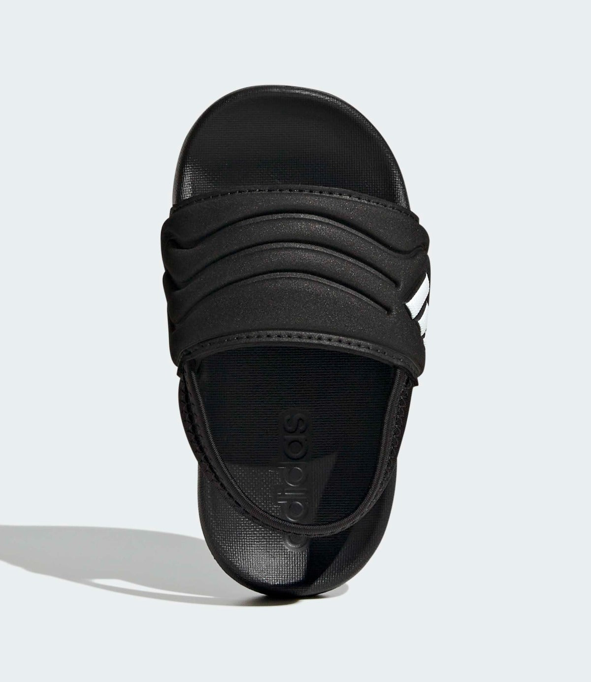 כפכף שחור עם רצועה עבה ועיטורים לבנים, צילום תקריב על רקע אפור