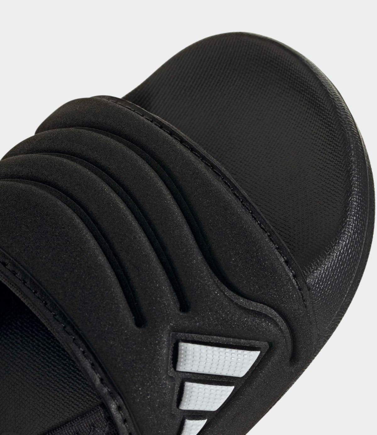 סנדל שחור אופנתי עם קווים מרופדים ועיצוב מודרני, תצלום תקריב על החלק הקדמי