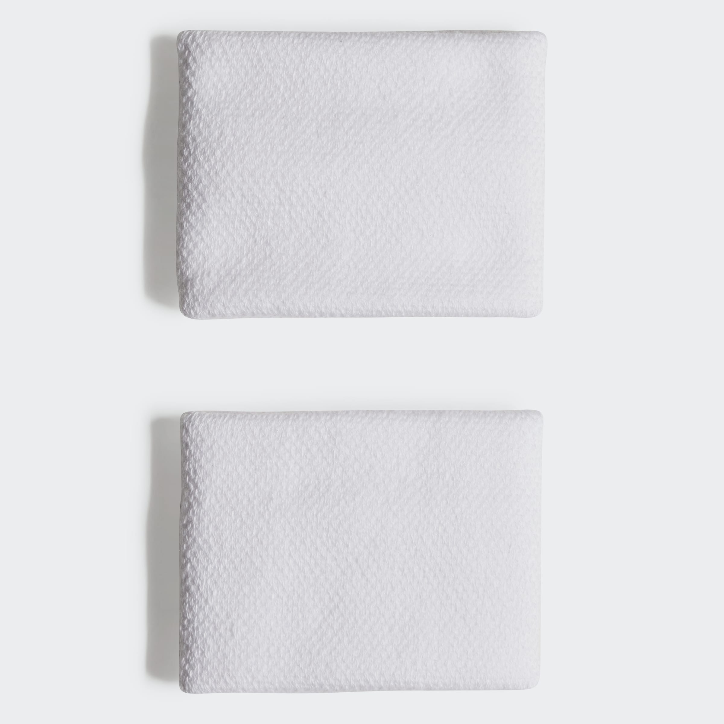 שתי מגבות ידיים לבנות מונחות על רקע לבן, טקסטורה עדינה לבד