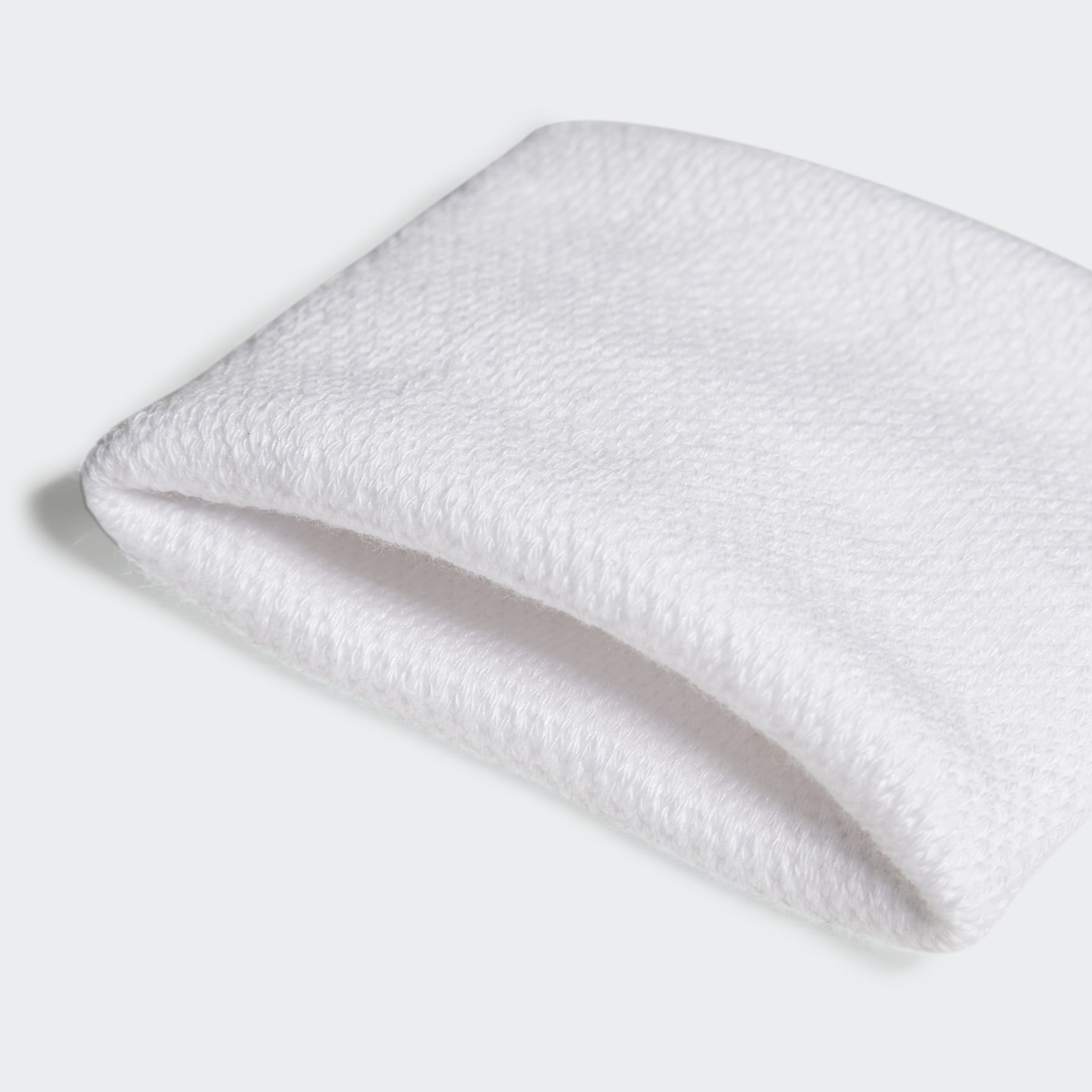 תקריב של סרט זיעה לבן מספורט מבד מגבת, מרקם רך ועדין, רקע אפור בהיר