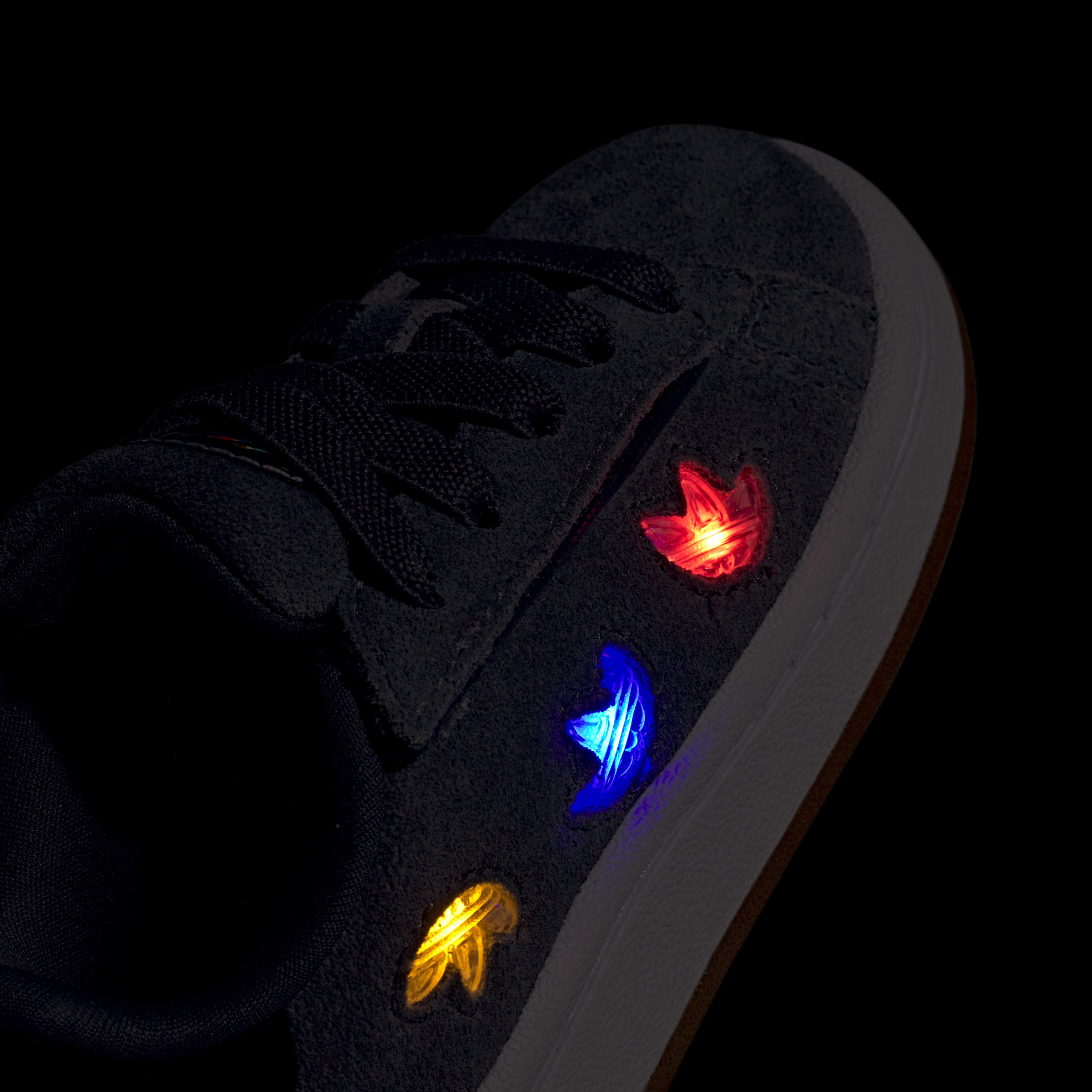 נעל ספורט כהה עם עיטורי תאורה צבעוניים באדום, כחול וצהוב בצד הנעל