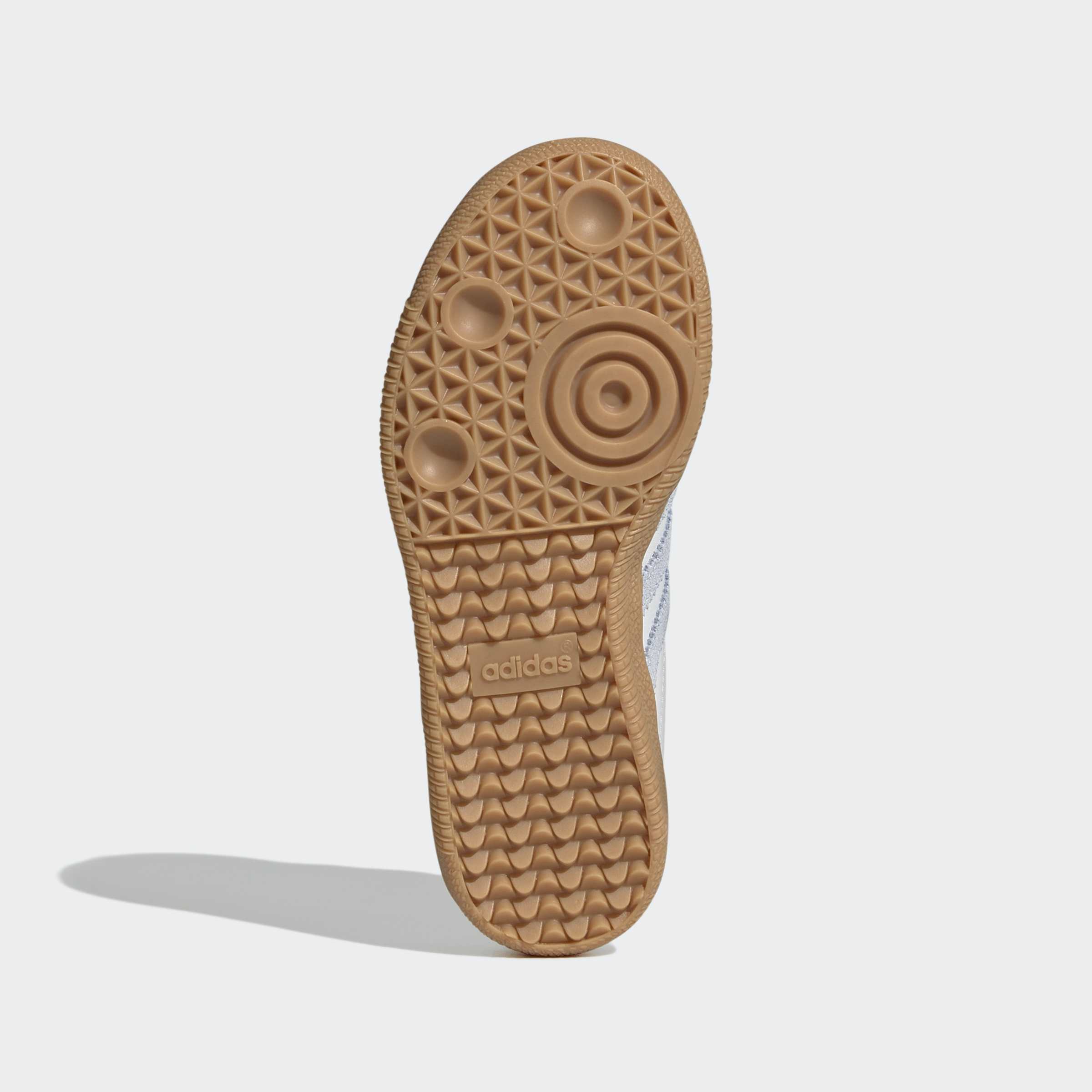 סוליית נעל ספורט בצבע חום עם דפוסים גאומטריים וסמל adidas