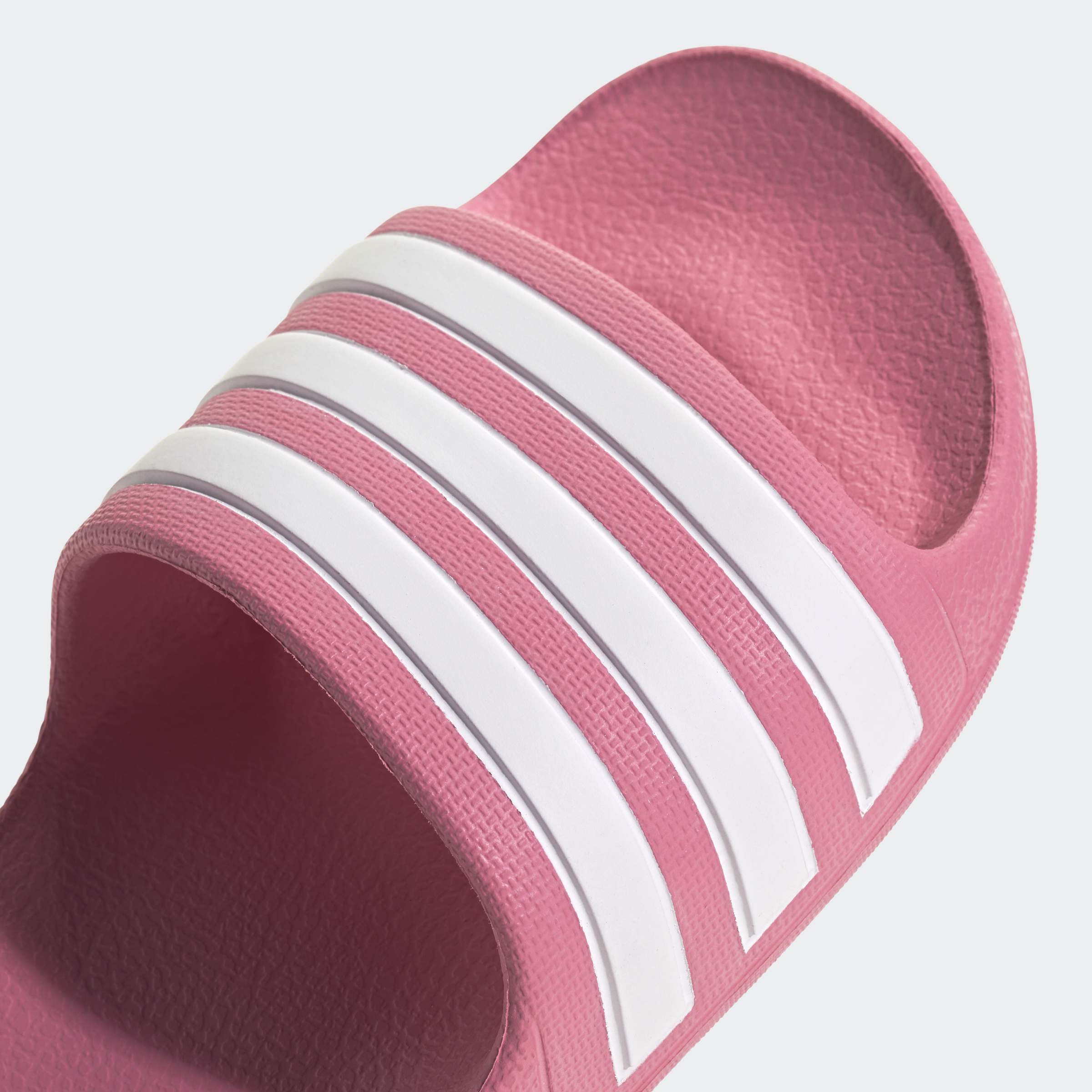 כפכף גומי ורוד עם שלושה פסים לבנים, צילום תקריב של חלק קדמי